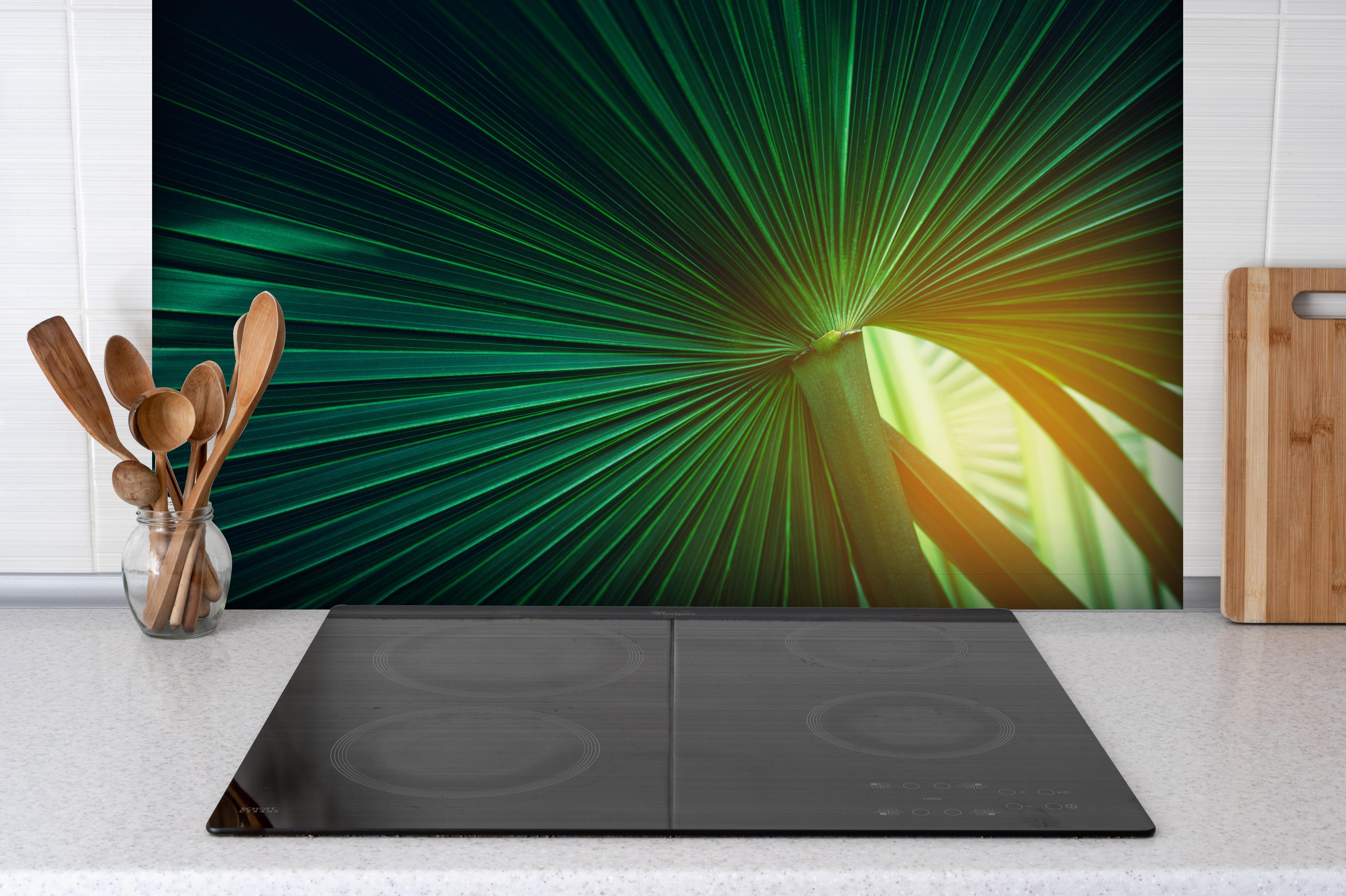 Spritzschutz - Grüne Blatt Textur hinter einem Cerankochfeld zwischen Holz-Kochutensilien
