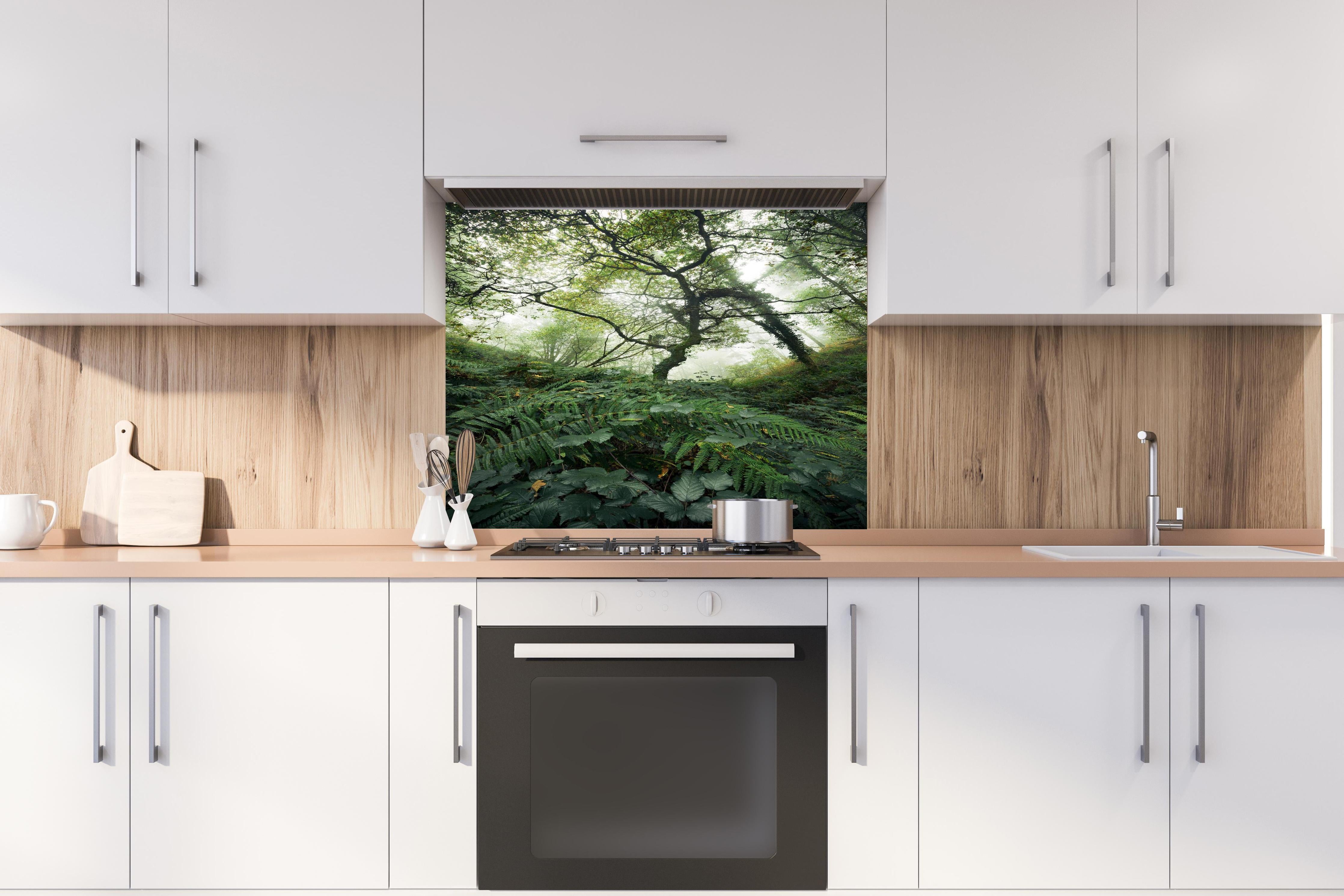 Spritzschutz - Grüner Nebelwald mit Herbstlaub hinter einem Cerankochfeld zwischen Holz-Kochutensilien