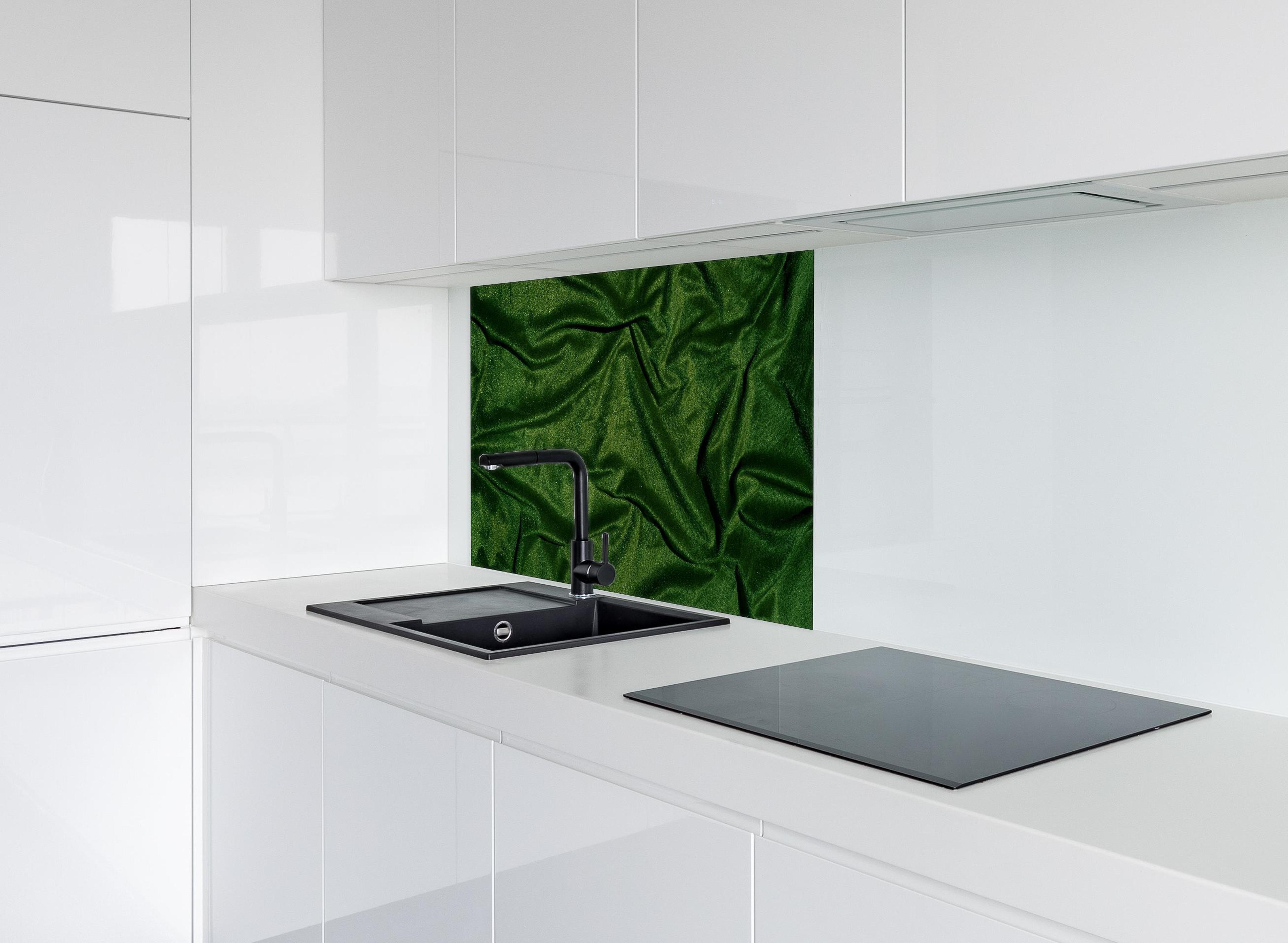 Spritzschutz - Grüner Seidenstoff Hintergrund hinter einem Cerankochfeld zwischen Holz-Kochutensilien