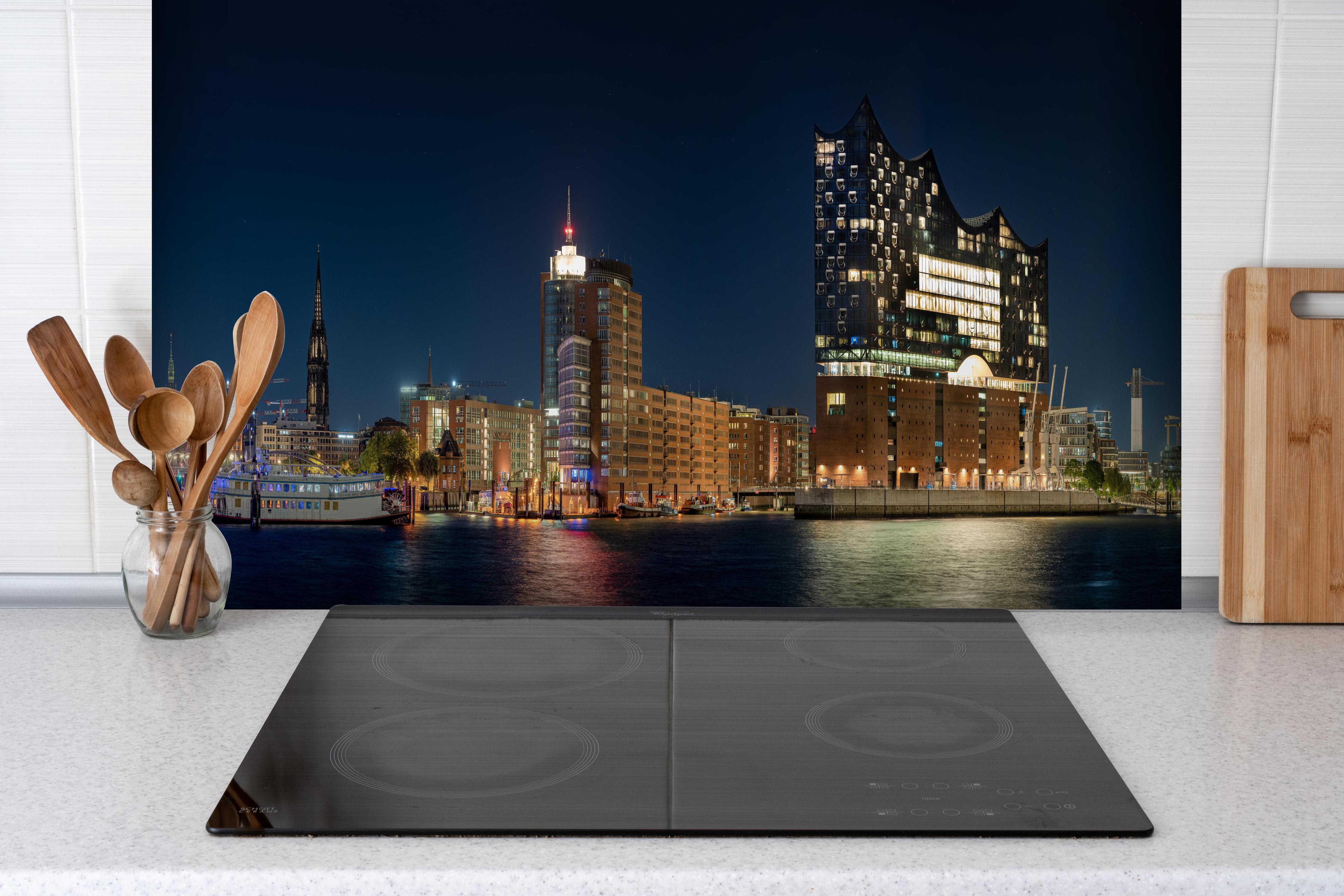 Spritzschutz - Hamburg bei Nacht hinter einem Cerankochfeld zwischen Holz-Kochutensilien