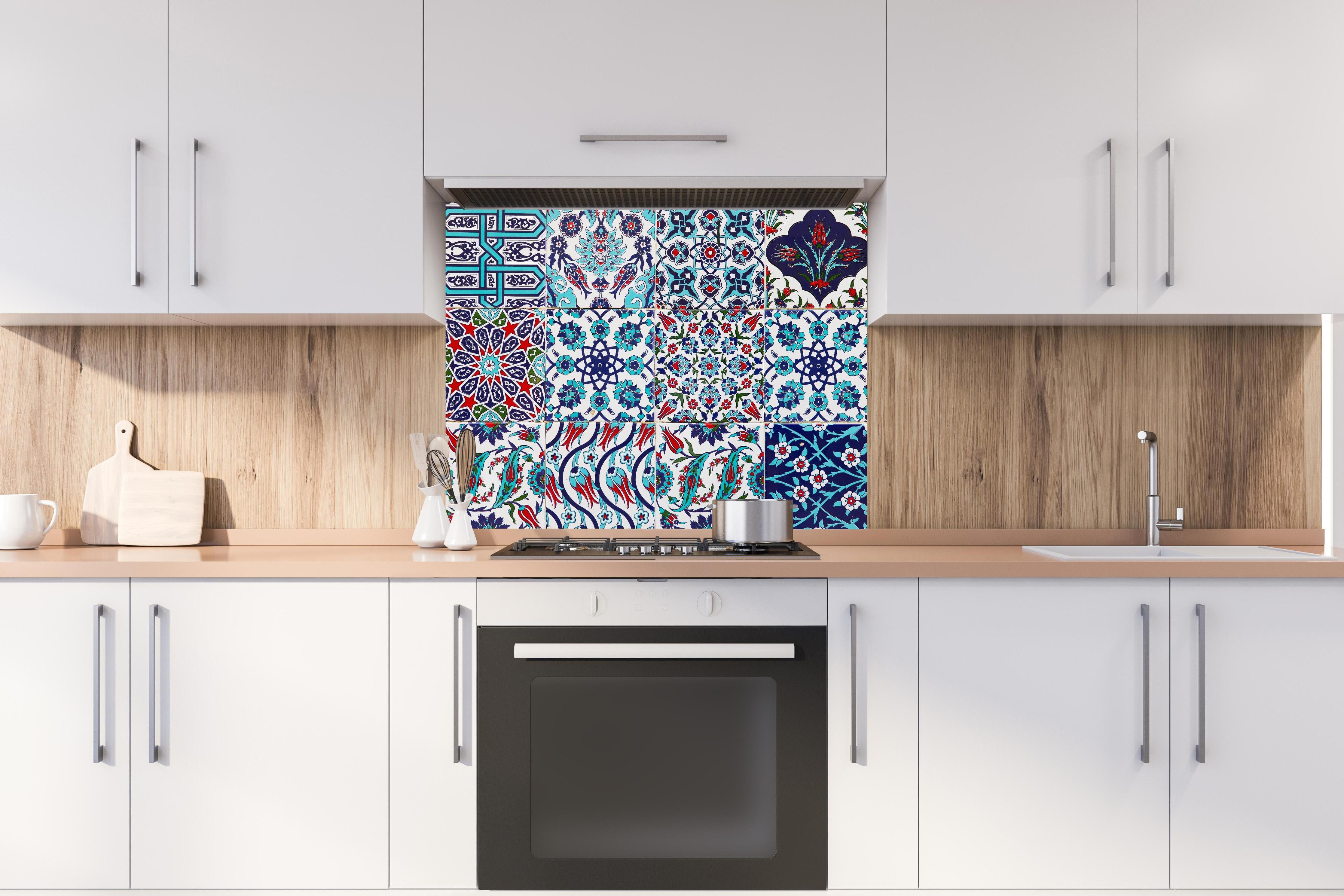 Spritzschutz - Handgefertigte osmanische Fliesen Türkisblau hinter einem Cerankochfeld zwischen Holz-Kochutensilien