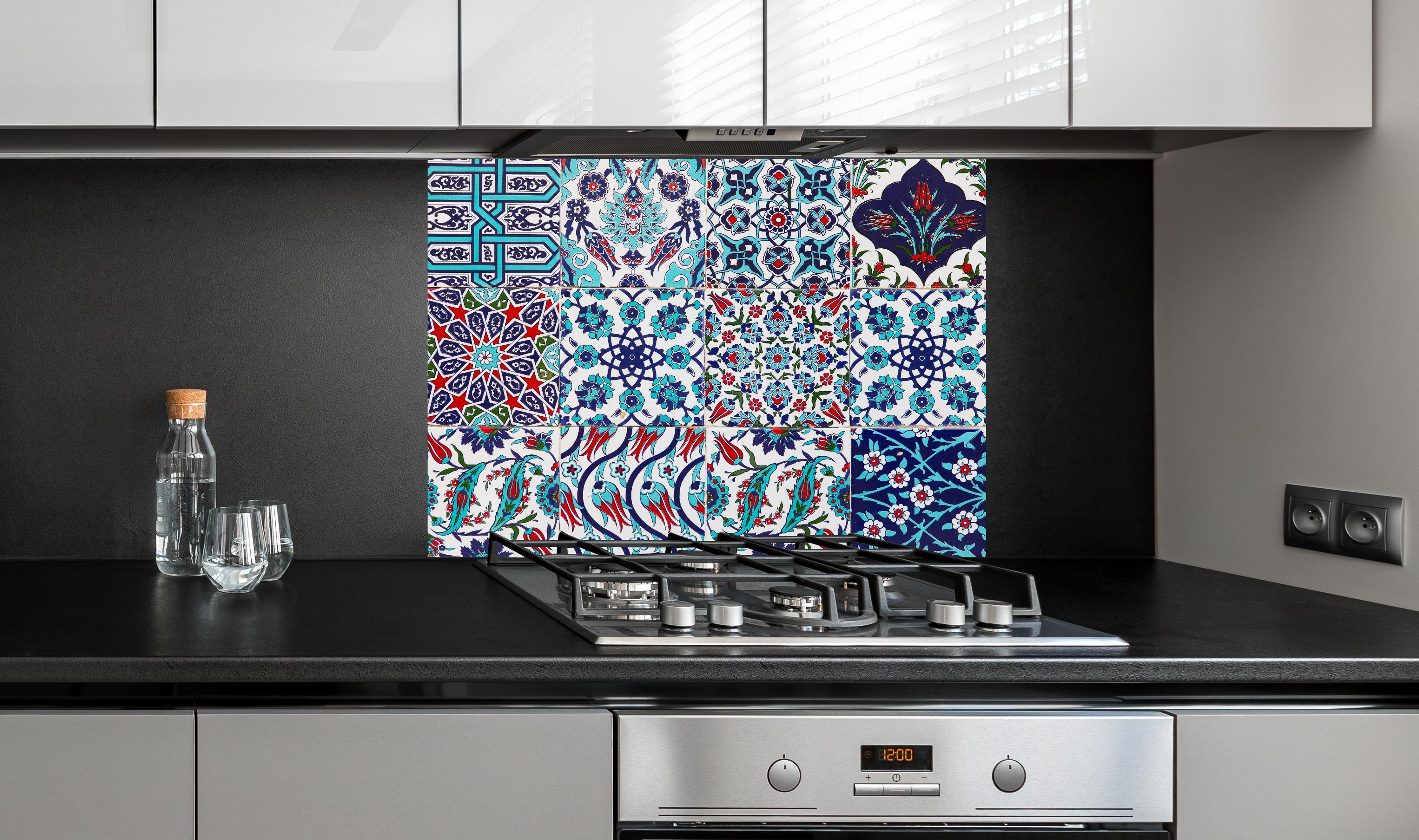 Spritzschutz - Handgefertigte osmanische Fliesen Türkisblau hinter einem Cerankochfeld zwischen Holz-Kochutensilien