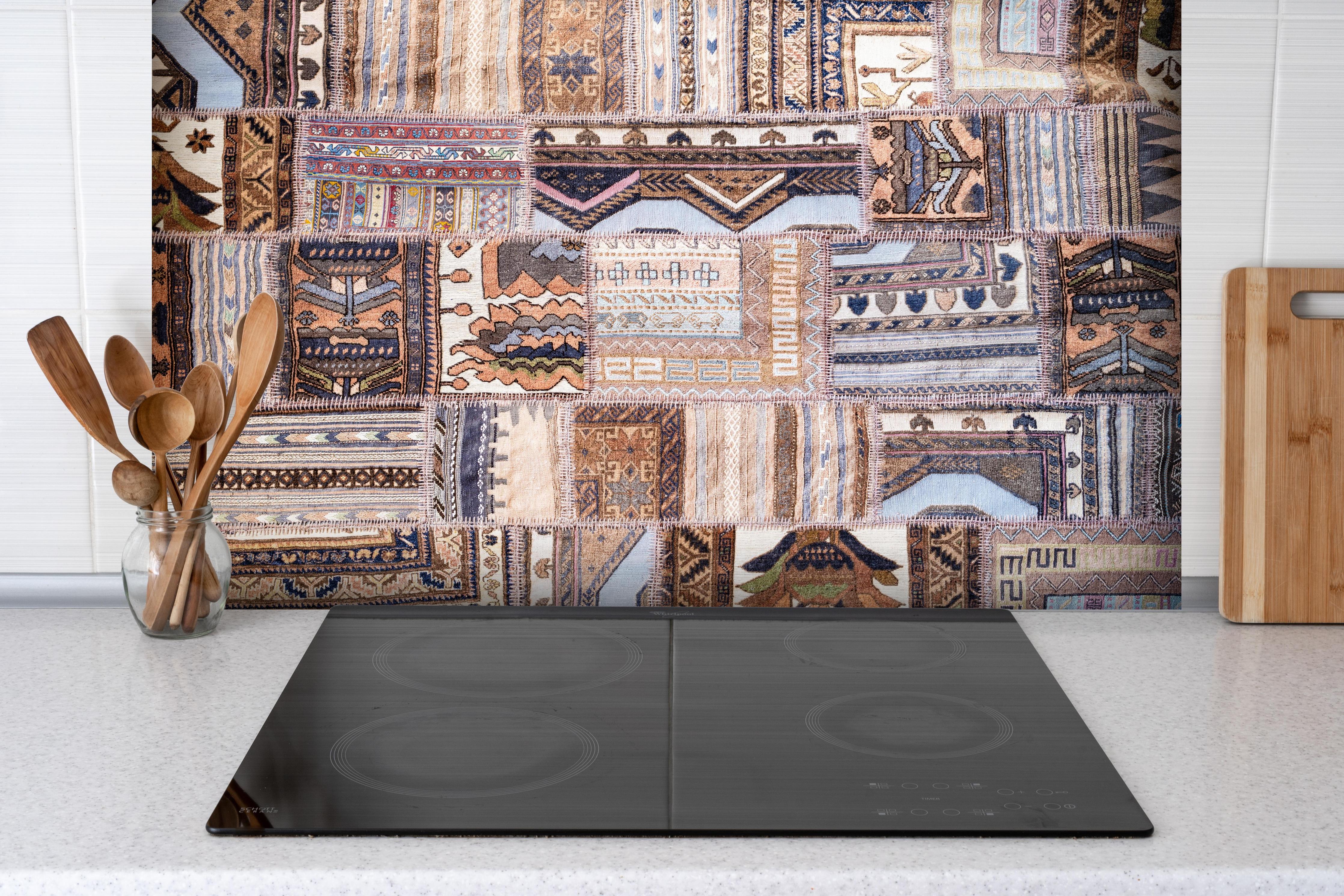 Spritzschutz - Handgemachte Türkische Kilim Teppichdesigns hinter einem Cerankochfeld zwischen Holz-Kochutensilien