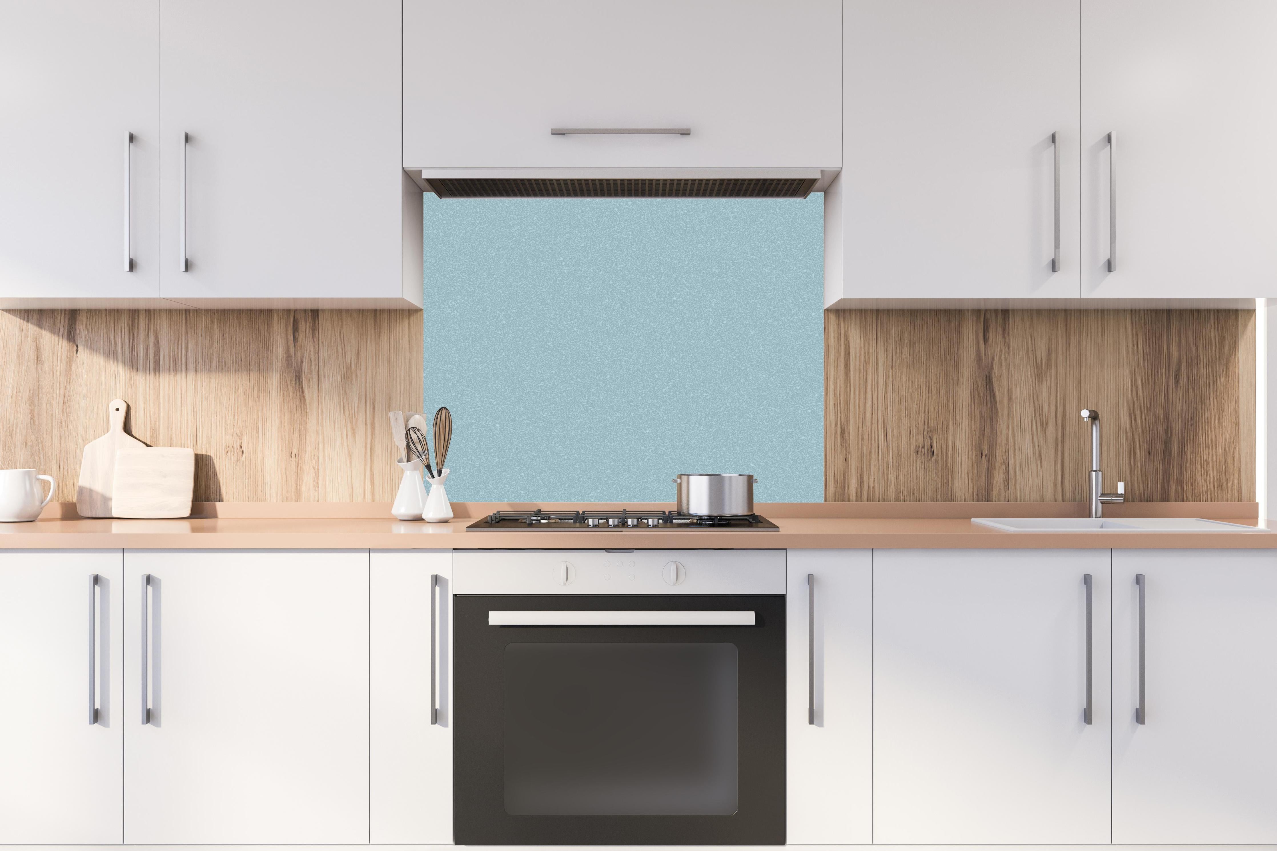 Spritzschutz - Hellblaue Wandtextur hinter einem Cerankochfeld zwischen Holz-Kochutensilien