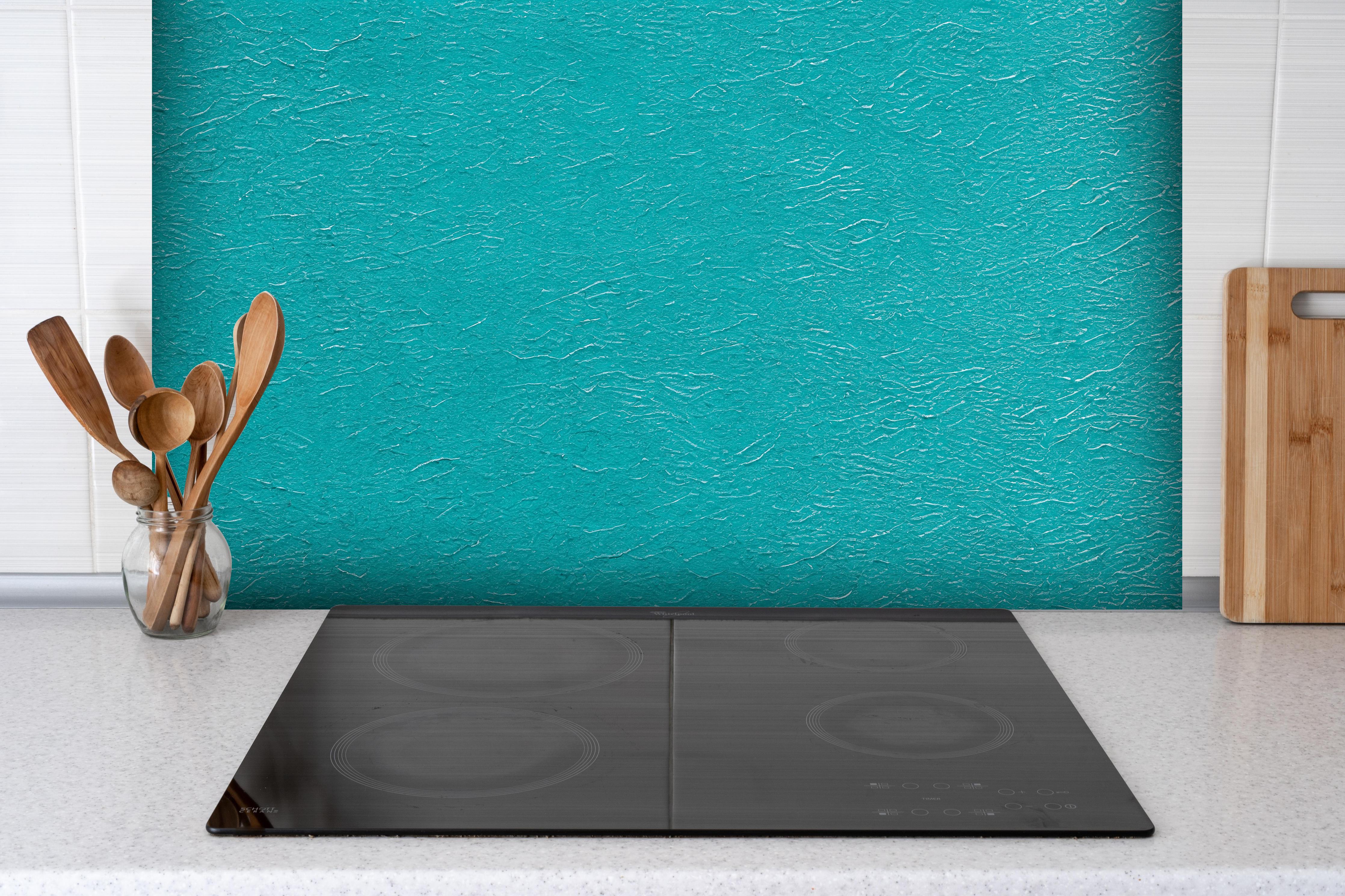 Spritzschutz - Hellblaue bemalte Wand Textur hinter einem Cerankochfeld zwischen Holz-Kochutensilien