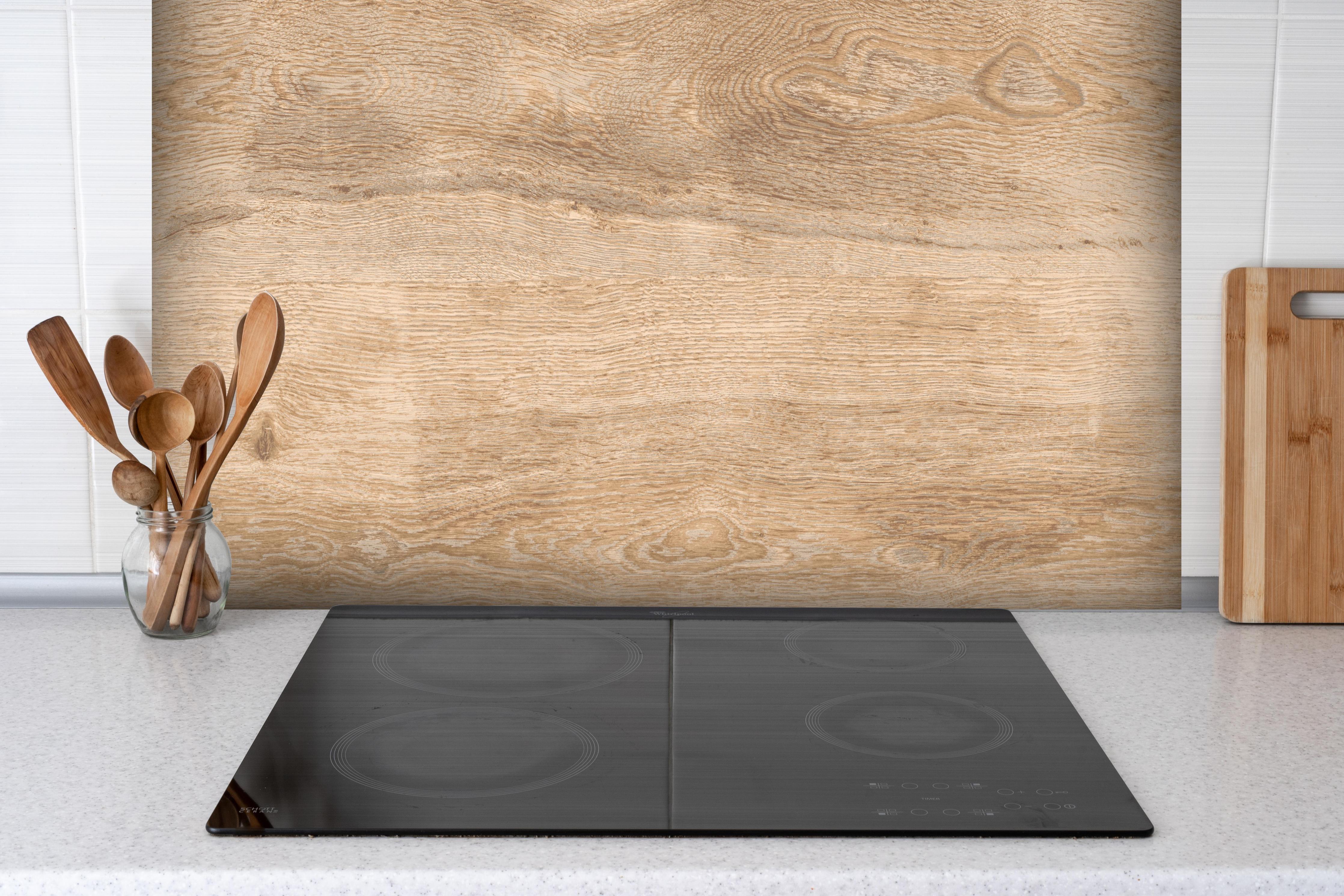 Spritzschutz - Hellbraunes Eichenholz hinter einem Cerankochfeld zwischen Holz-Kochutensilien