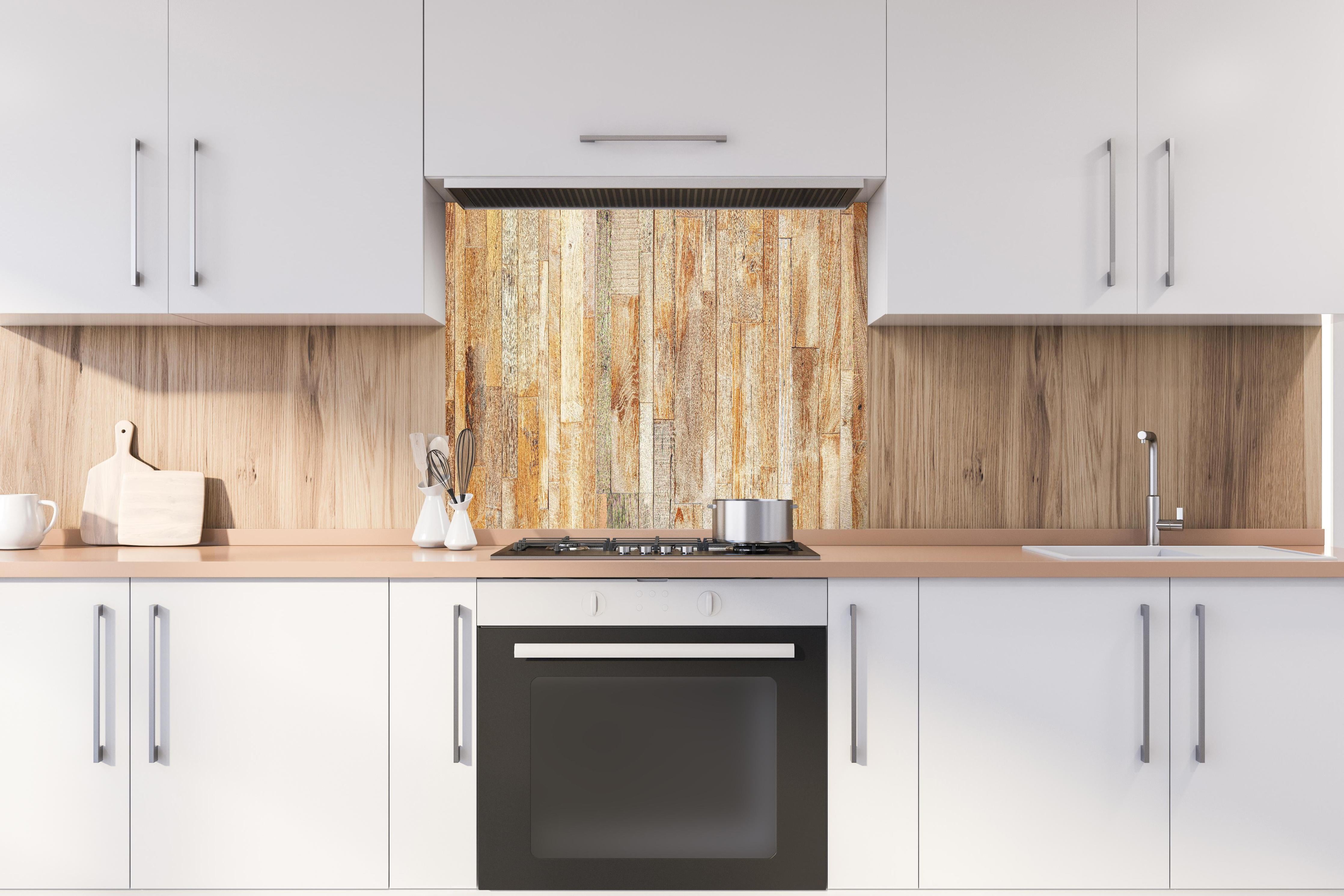 Spritzschutz - Heller Holzhintergrund hinter einem Cerankochfeld zwischen Holz-Kochutensilien