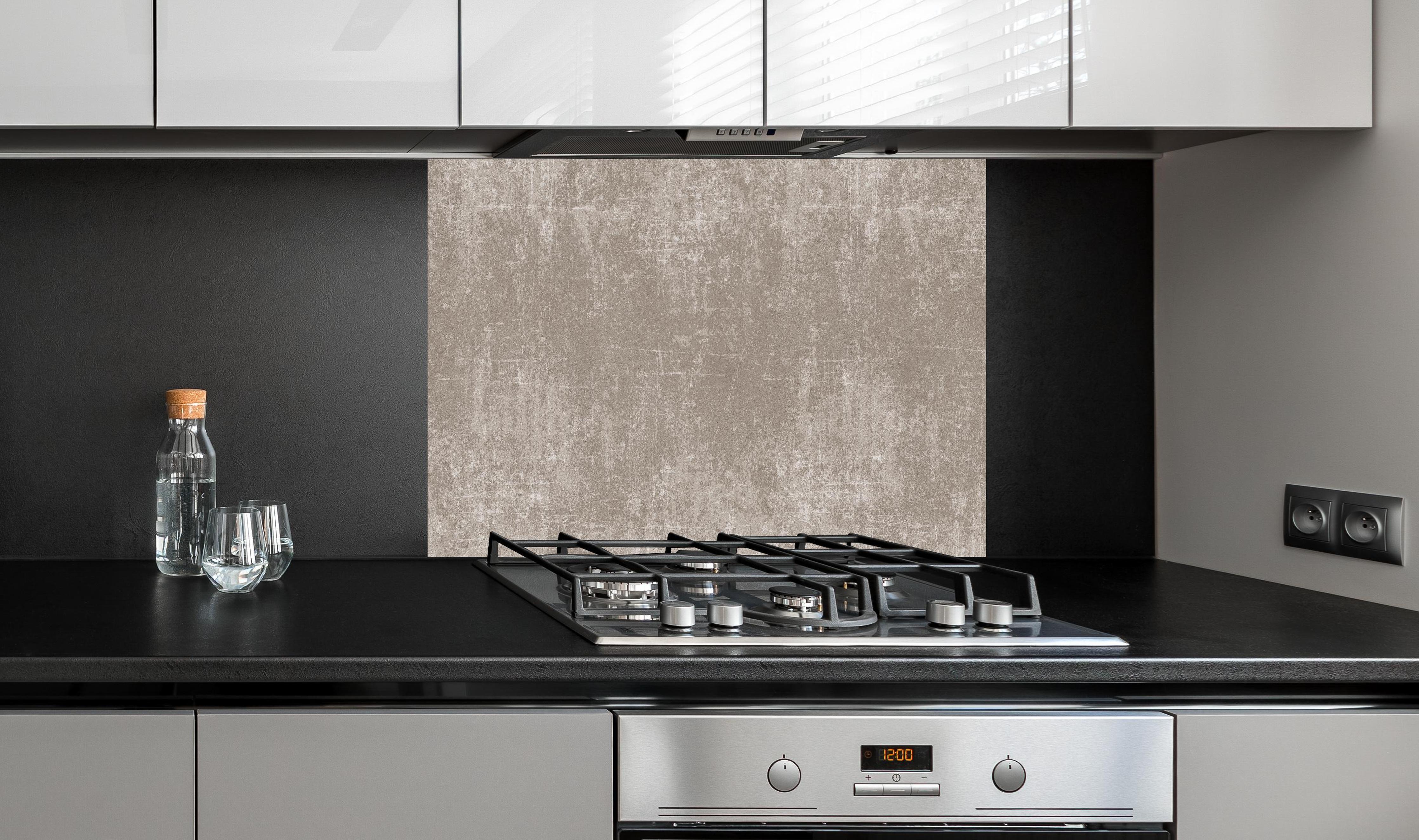 Spritzschutz - Heller Zementhintergrund hinter einem Cerankochfeld zwischen Holz-Kochutensilien