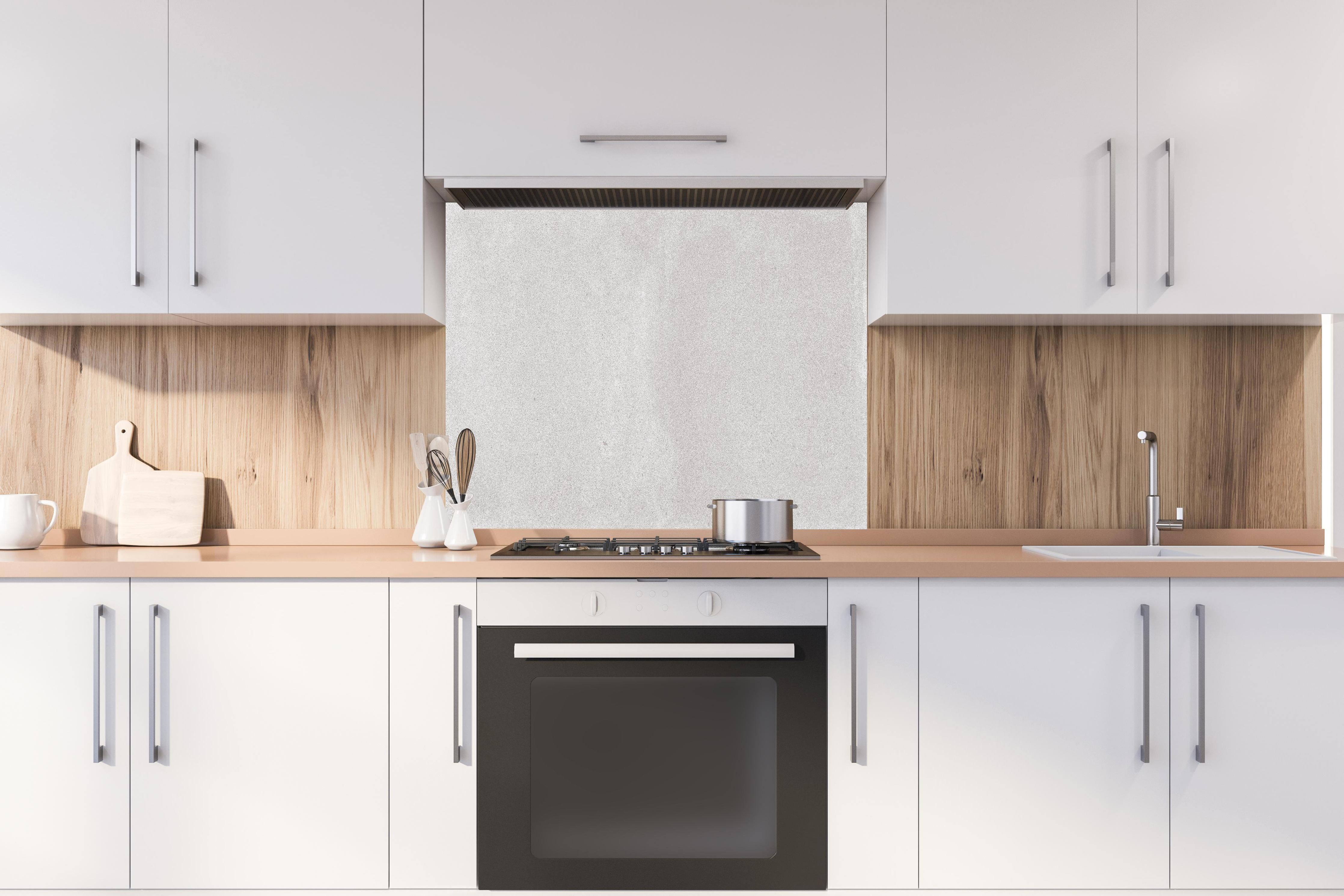 Spritzschutz - Hellgraues Mamor Design hinter einem Cerankochfeld zwischen Holz-Kochutensilien