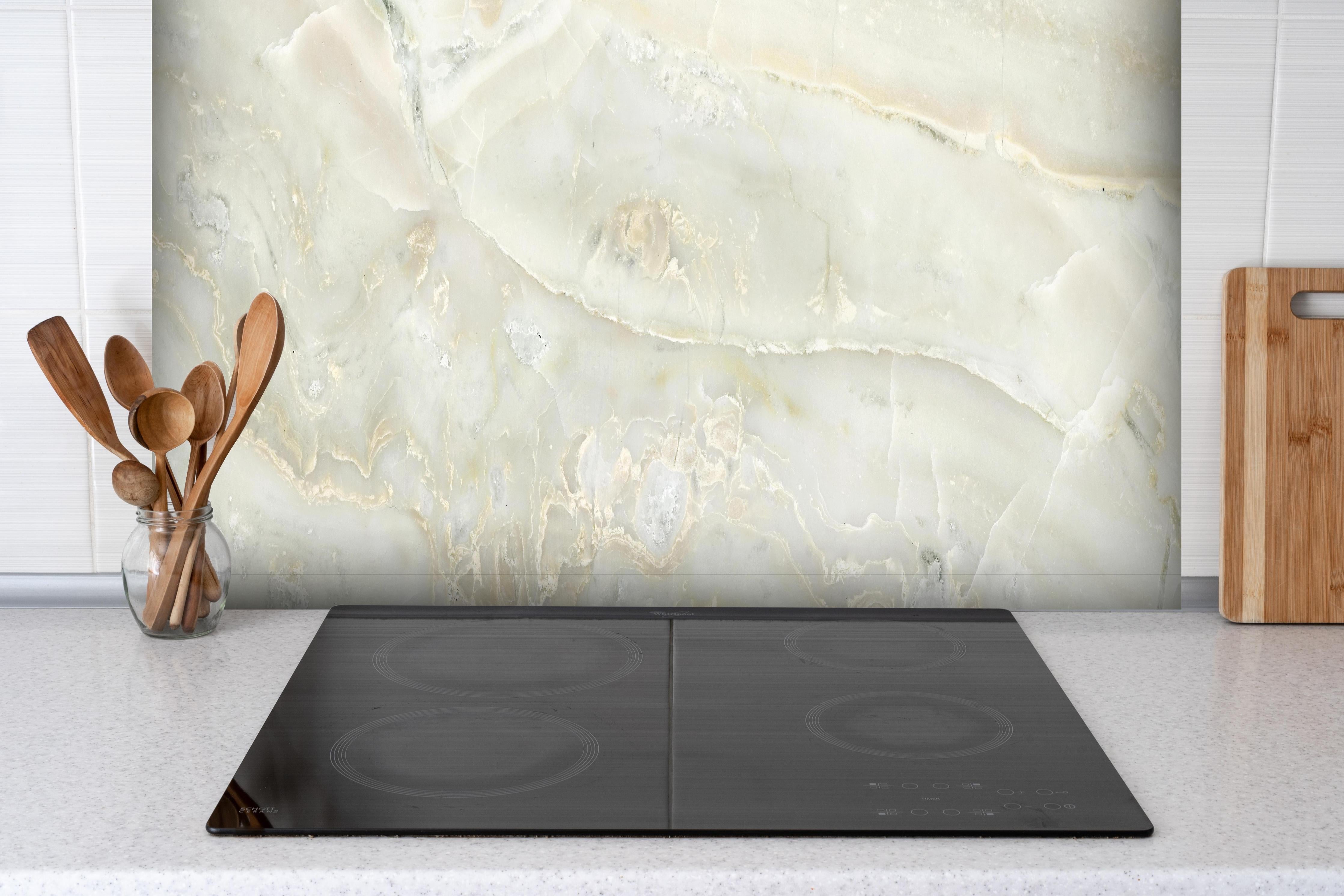 Spritzschutz - Hellgrüner Marmor hinter einem Cerankochfeld zwischen Holz-Kochutensilien