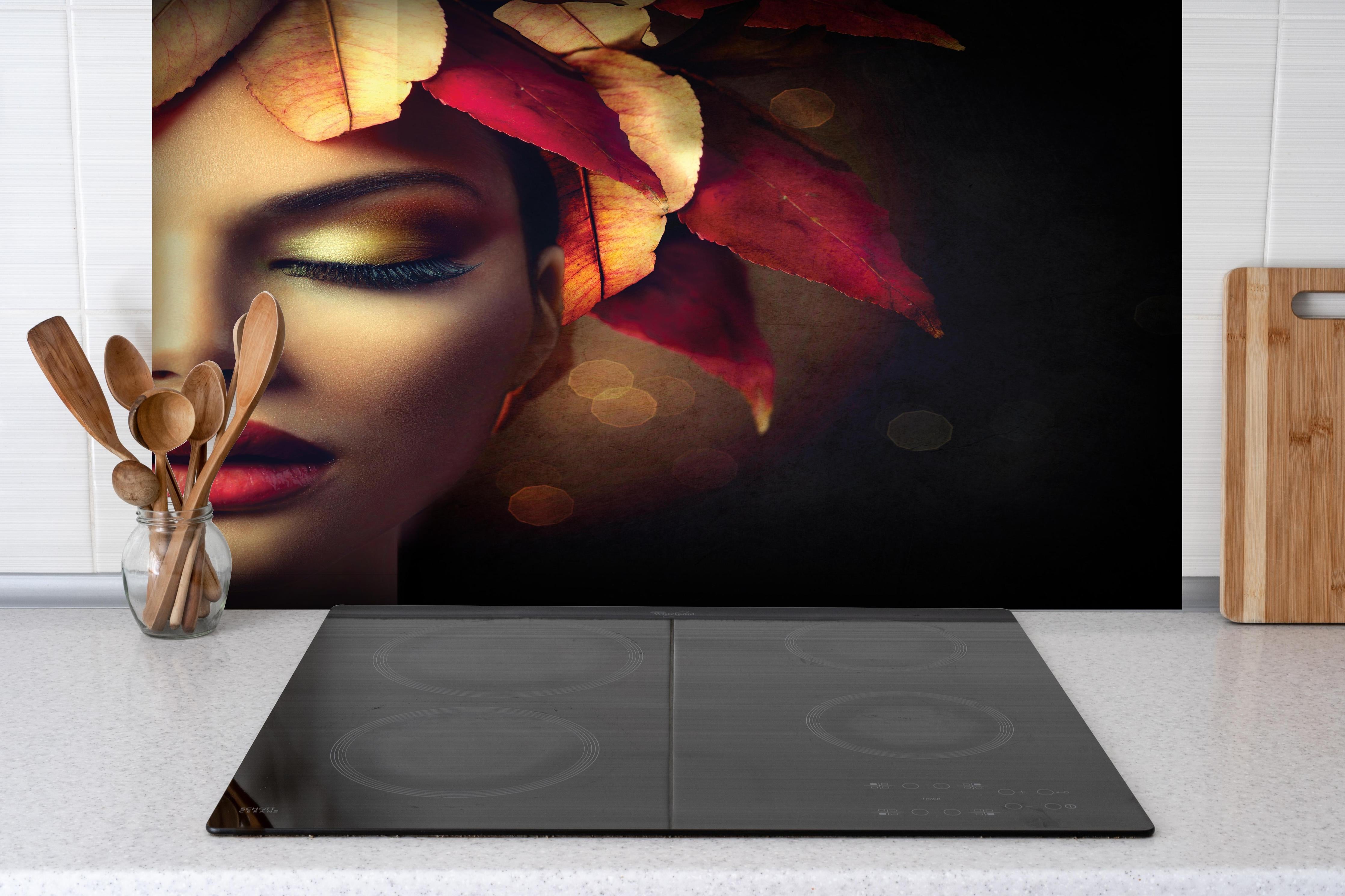 Spritzschutz - Herbstblätter Frisur auf dunklem Hintergrund hinter einem Cerankochfeld zwischen Holz-Kochutensilien