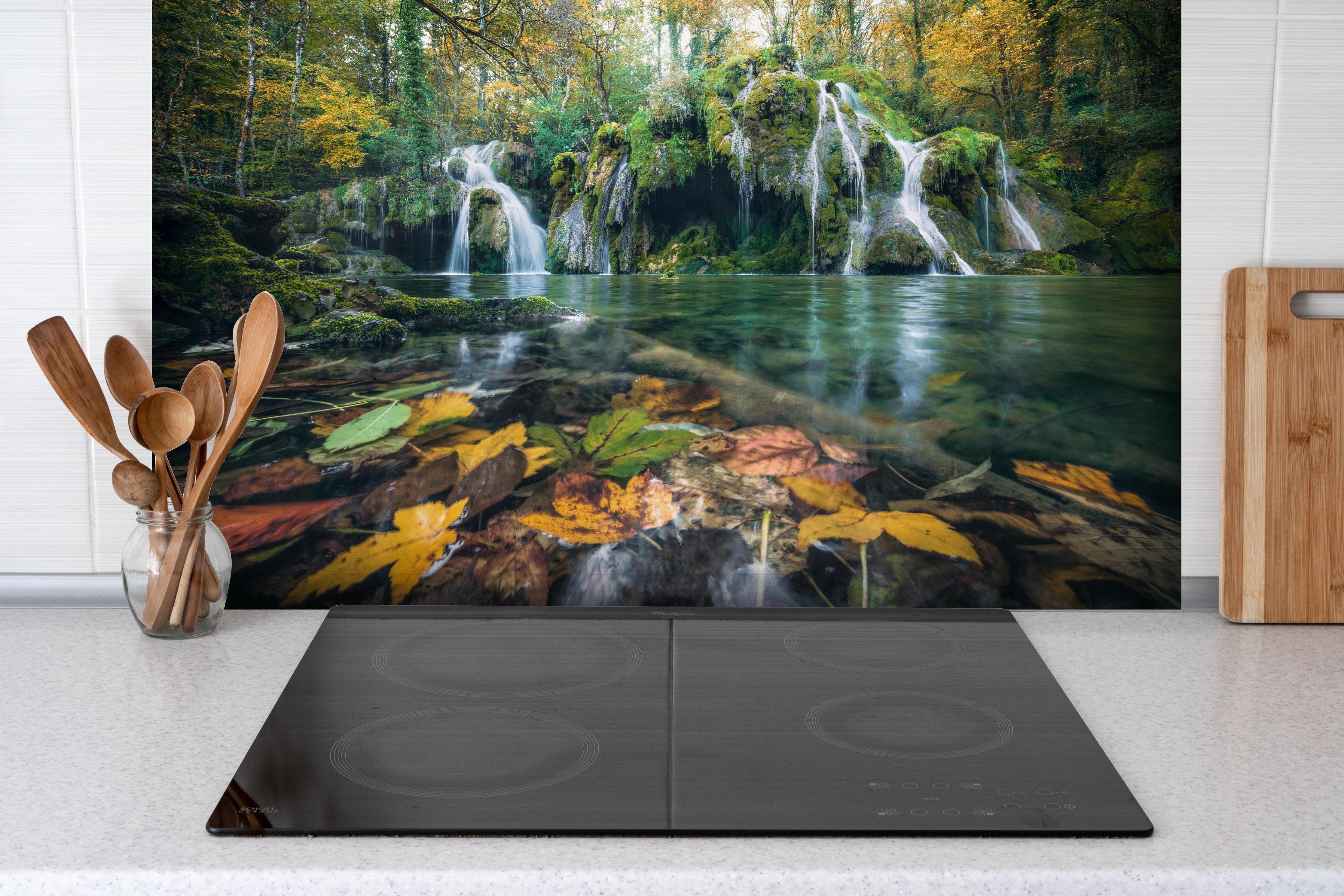 Spritzschutz - Herbstblätter im See hinter einem Cerankochfeld zwischen Holz-Kochutensilien