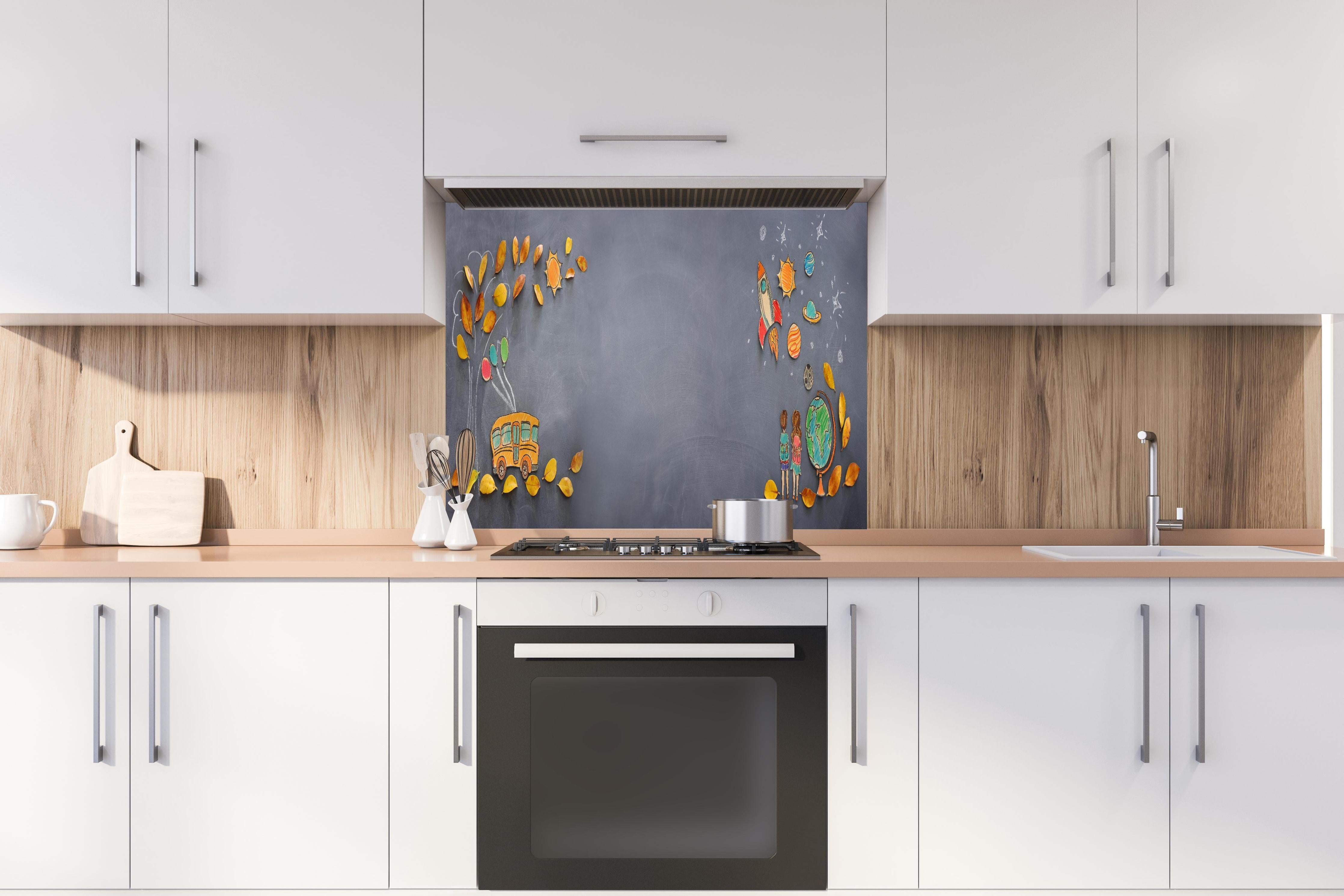 Spritzschutz - Herbstleaves und Schulbus auf Tafel hinter einem Cerankochfeld zwischen Holz-Kochutensilien