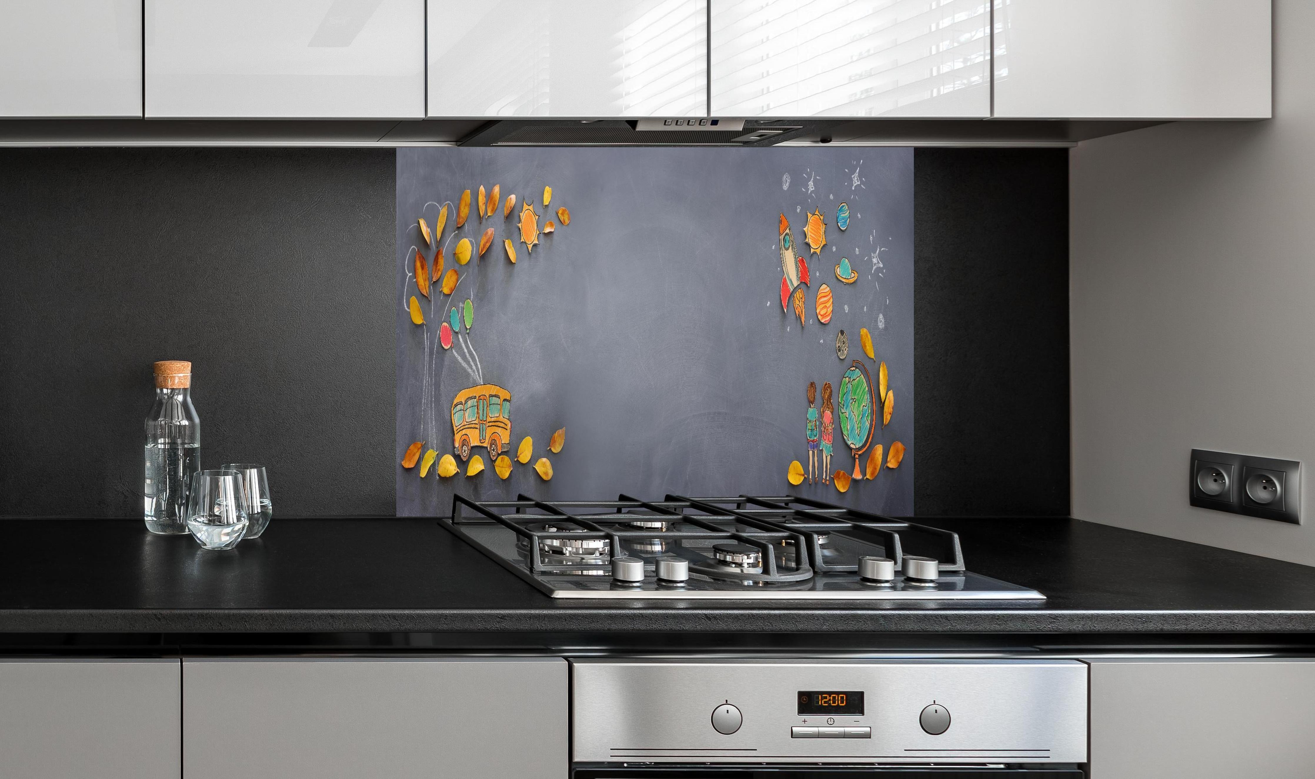 Spritzschutz - Herbstleaves und Schulbus auf Tafel hinter einem Cerankochfeld zwischen Holz-Kochutensilien