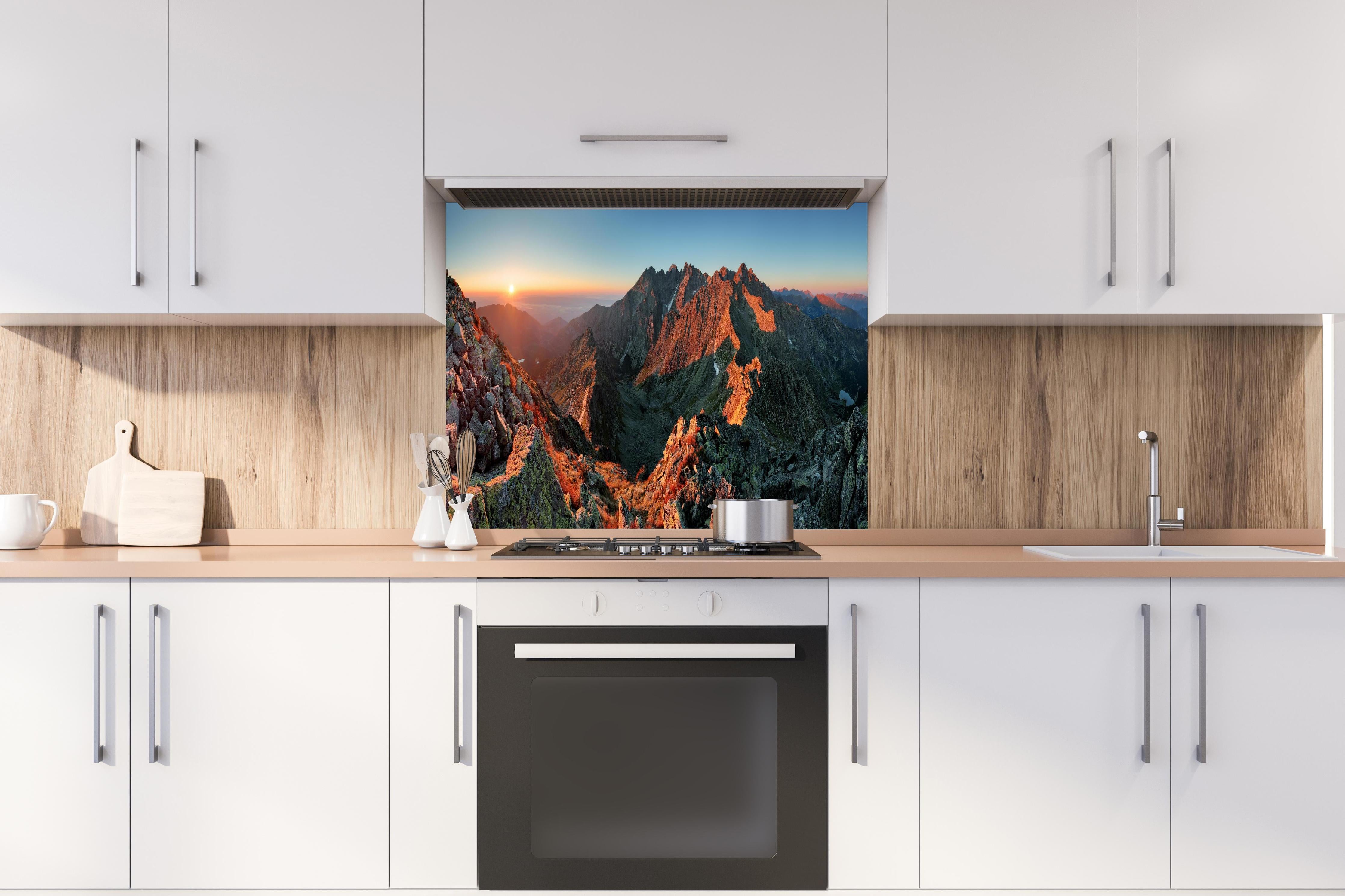 Spritzschutz - Herbstliche Berglandschaft hinter einem Cerankochfeld zwischen Holz-Kochutensilien