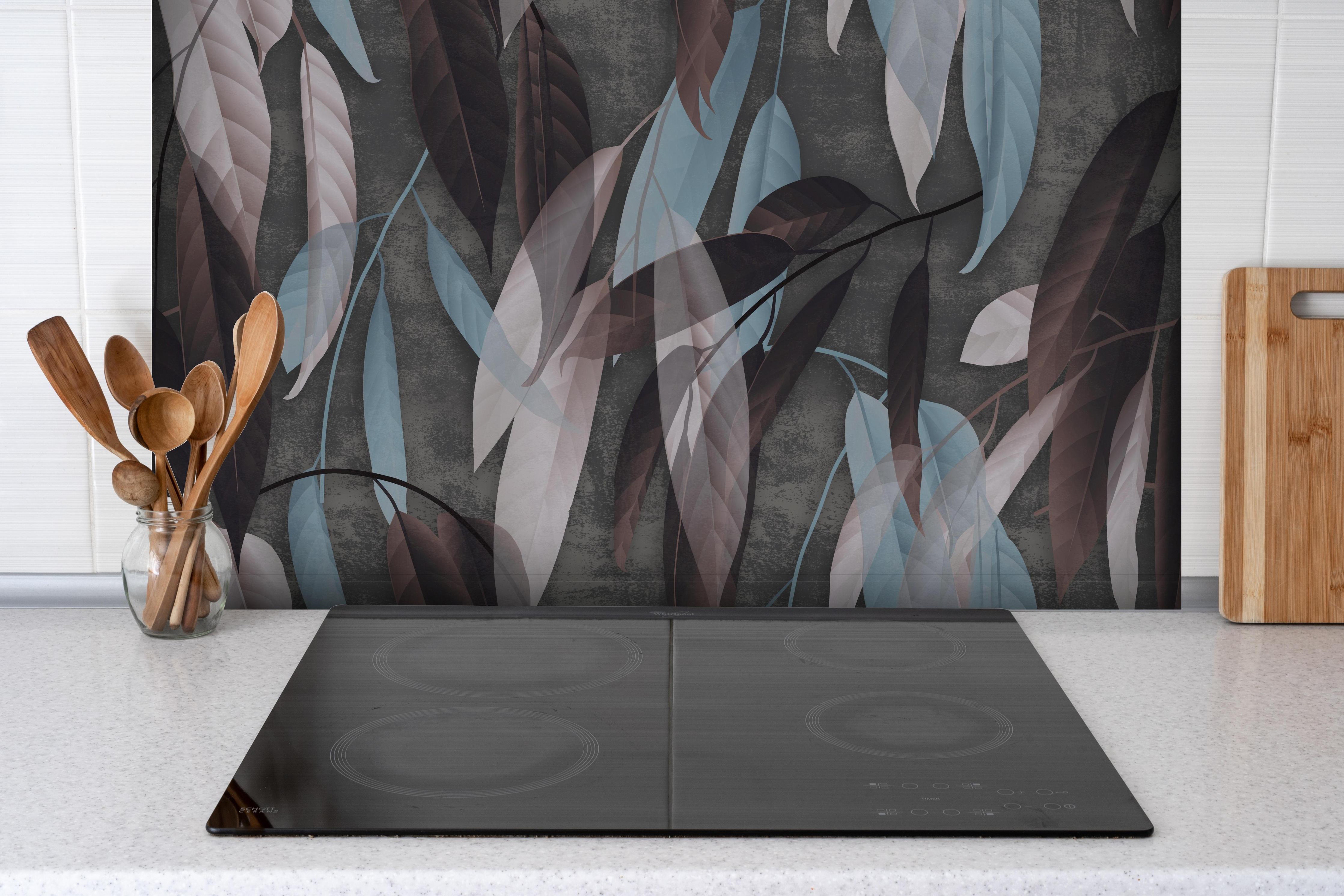 Spritzschutz - Herbstliche Blätter auf Betonoptik Tapete hinter einem Cerankochfeld zwischen Holz-Kochutensilien