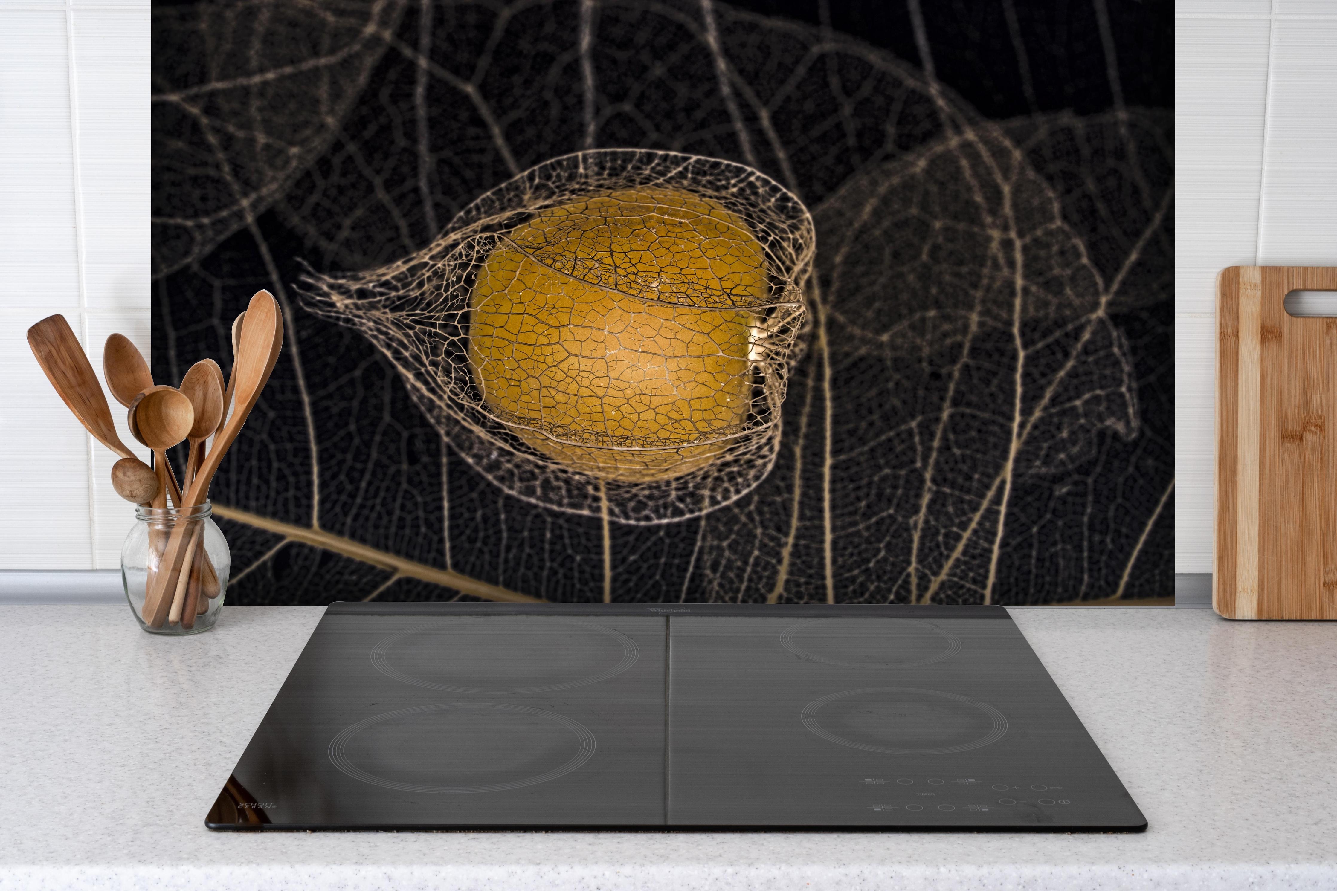 Spritzschutz - Herbstliches Blatt - Nahaufnahme hinter einem Cerankochfeld zwischen Holz-Kochutensilien