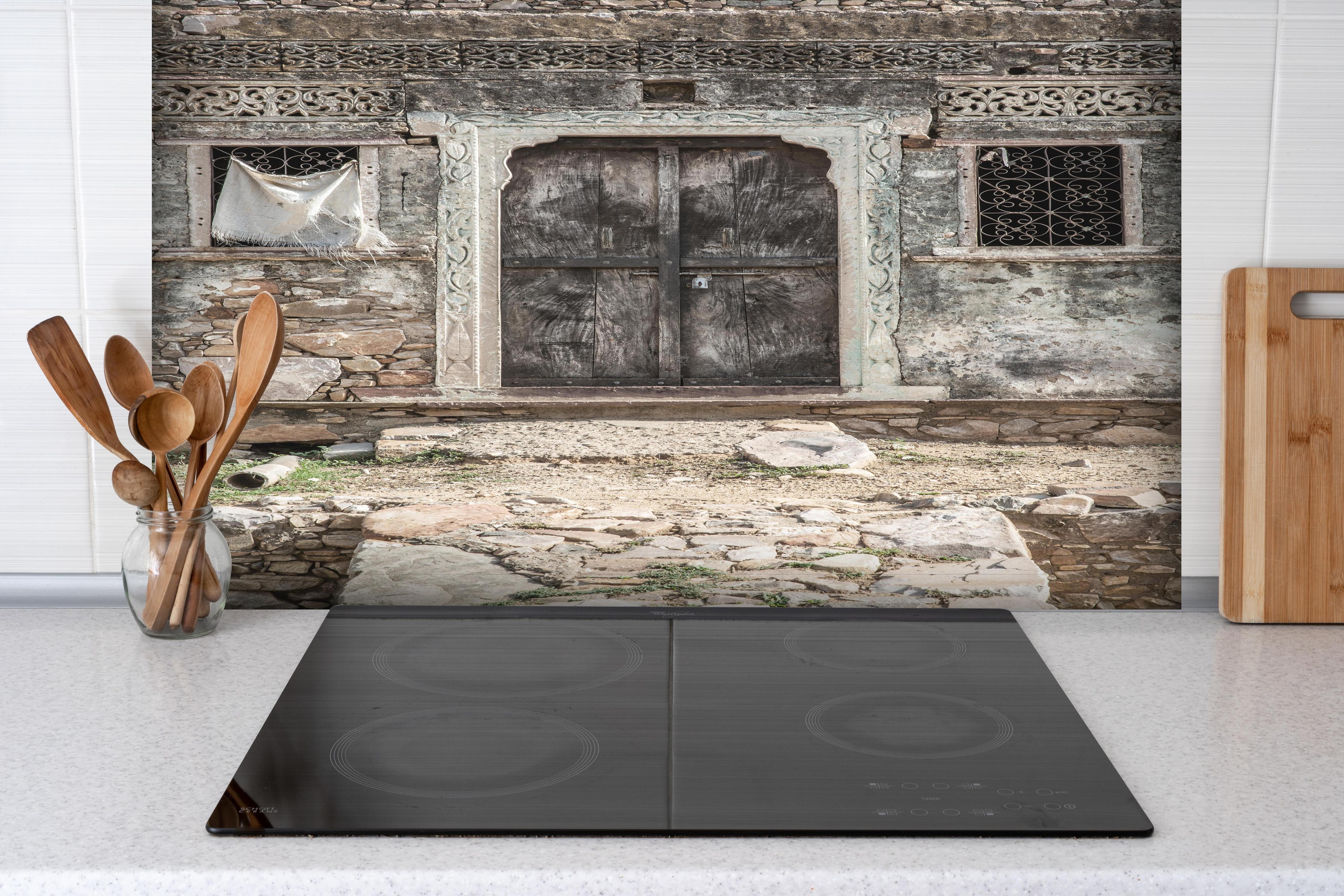 Spritzschutz - Historische Architektur - Eingang hinter einem Cerankochfeld zwischen Holz-Kochutensilien