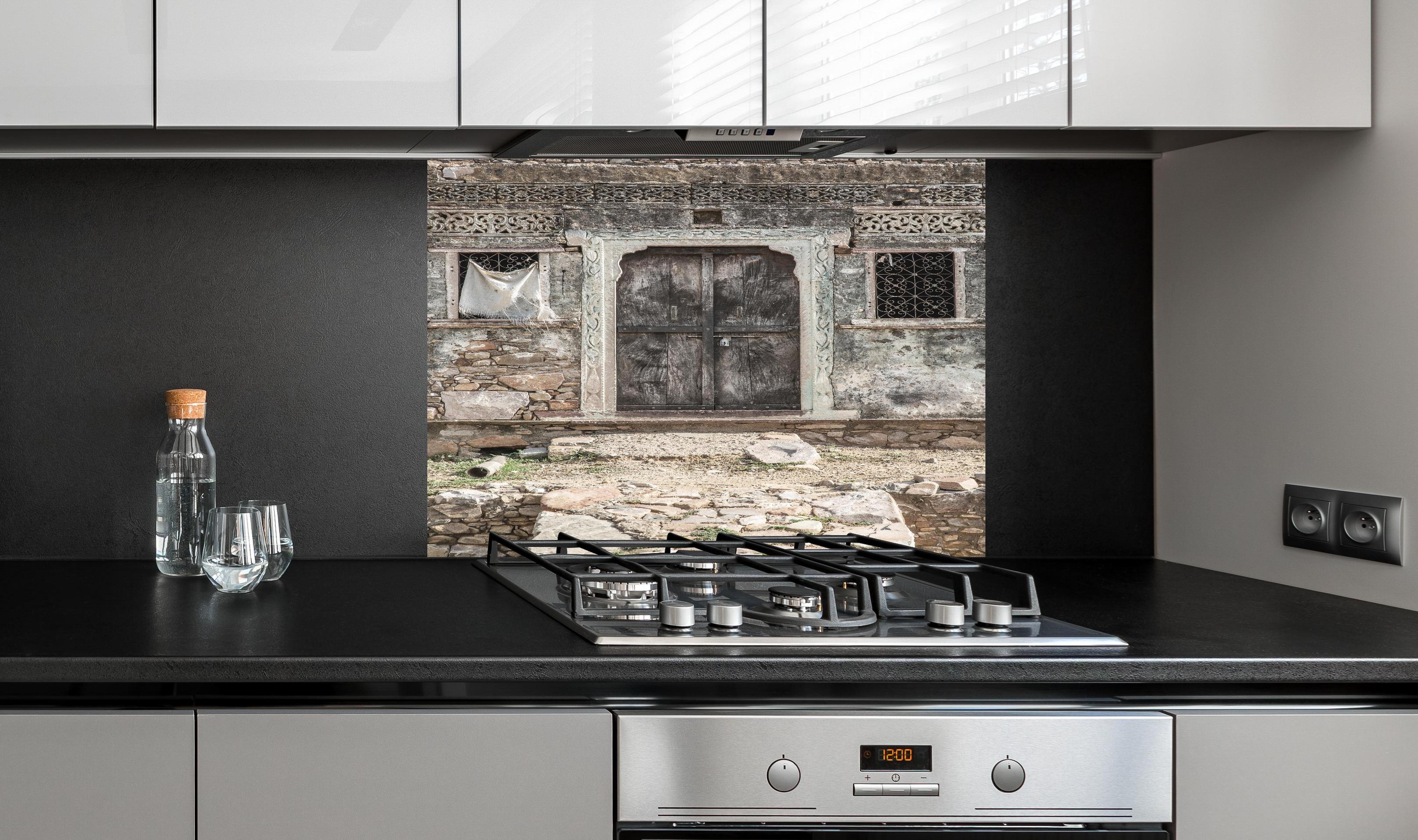 Spritzschutz - Historische Architektur - Eingang hinter einem Cerankochfeld zwischen Holz-Kochutensilien