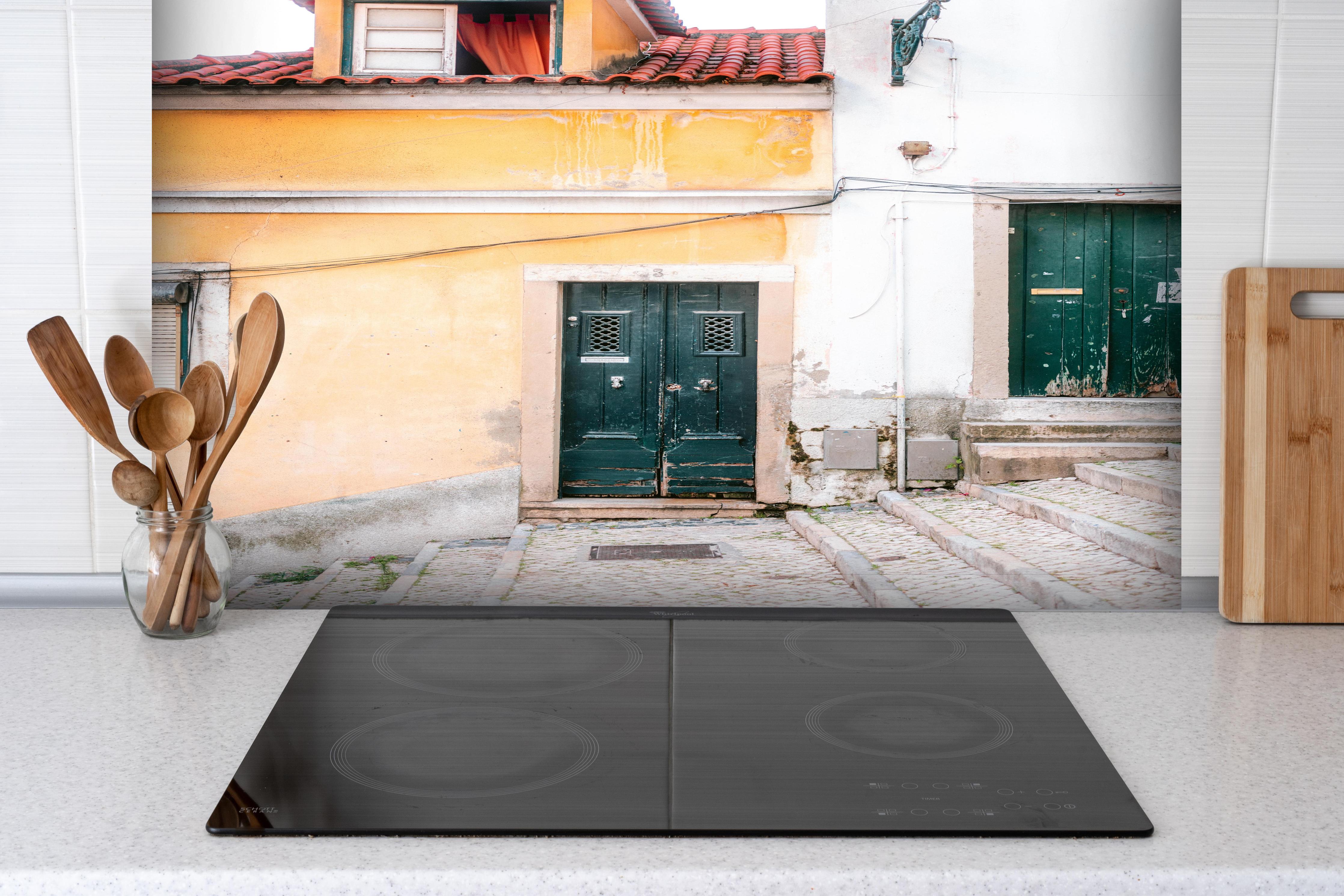 Spritzschutz - Historische Stadthaus Fassade in Lissabon hinter einem Cerankochfeld zwischen Holz-Kochutensilien