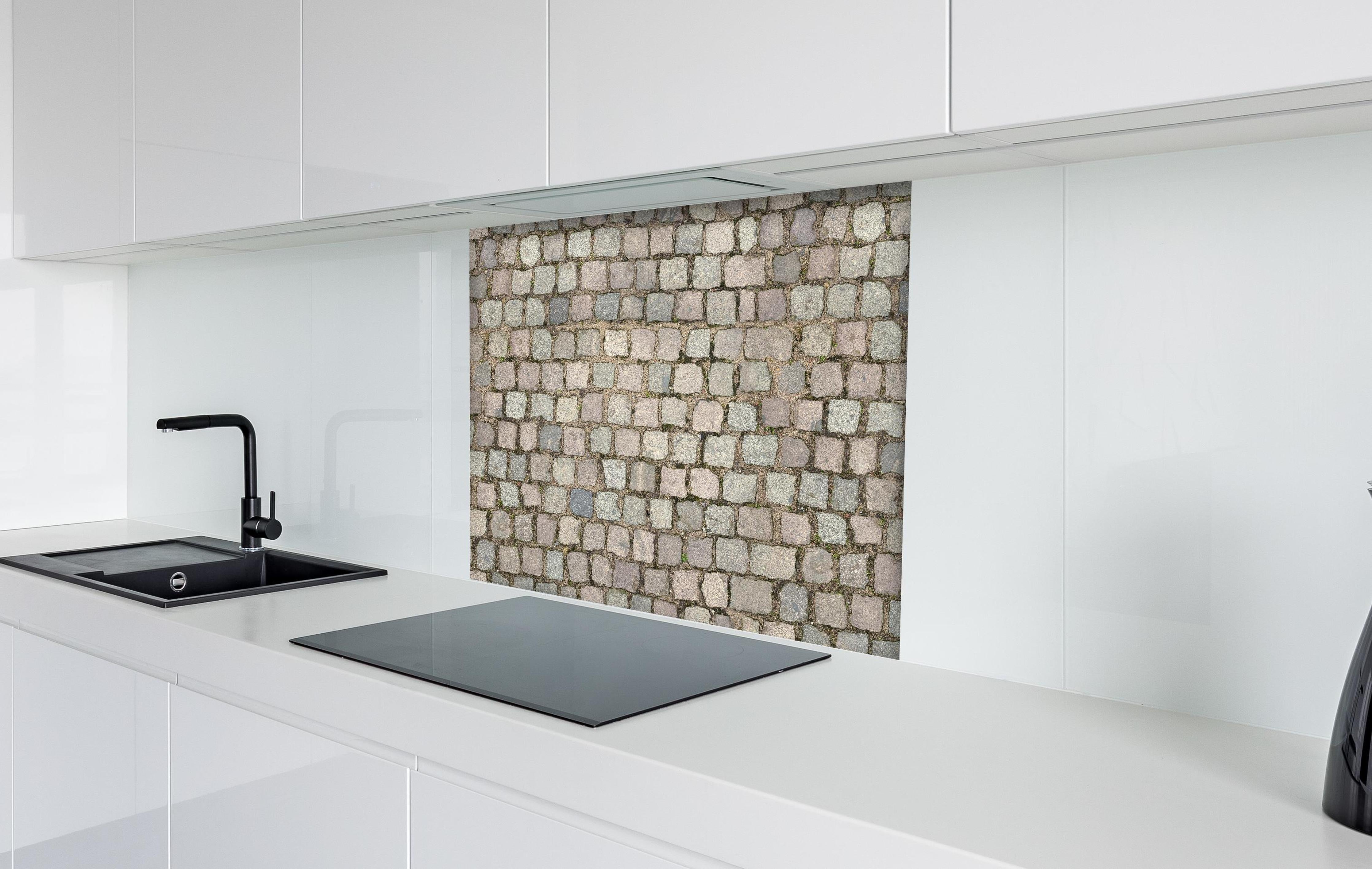 Spritzschutz - Historisches Grau-Braunes Kopfsteinpflaster hinter einem Cerankochfeld zwischen Holz-Kochutensilien