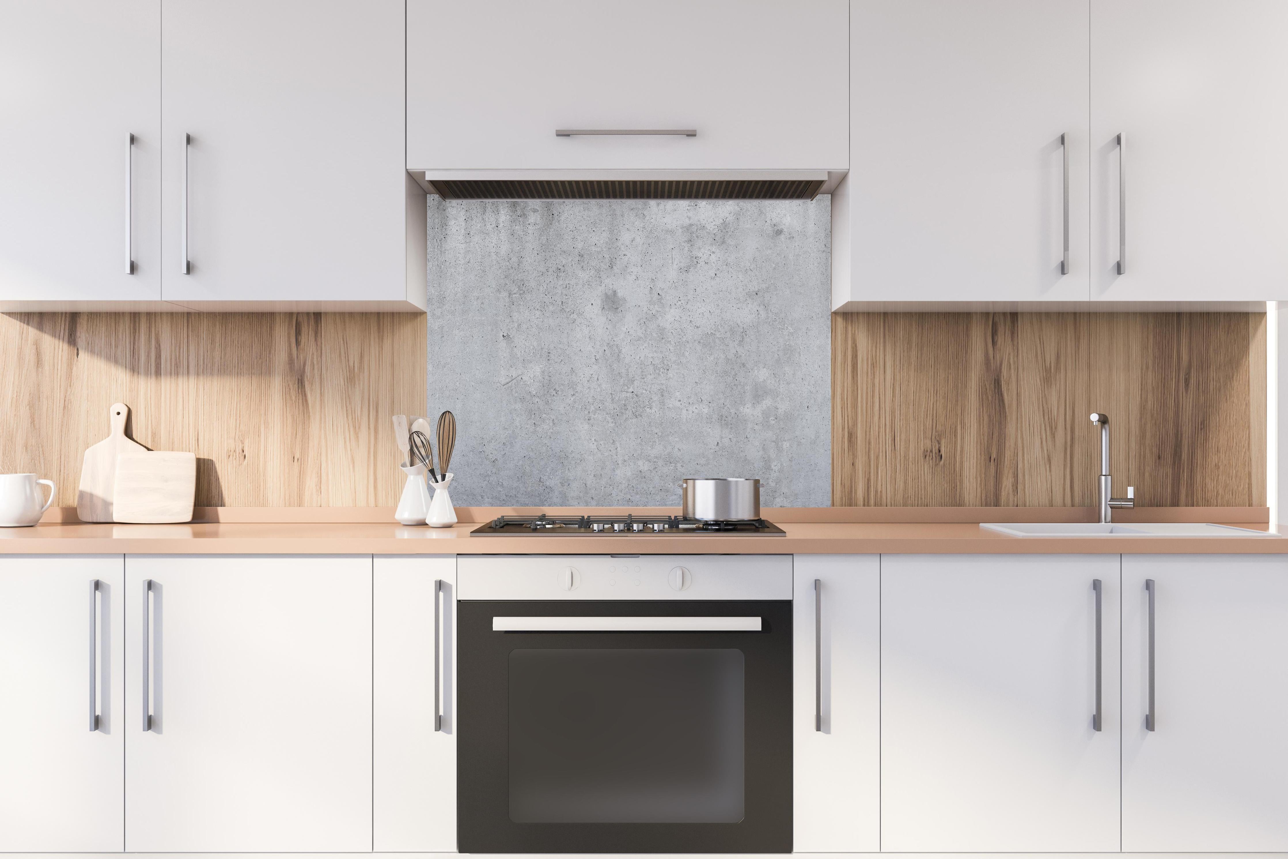 Spritzschutz - Hochauflösende Beton-Tapete hinter einem Cerankochfeld zwischen Holz-Kochutensilien