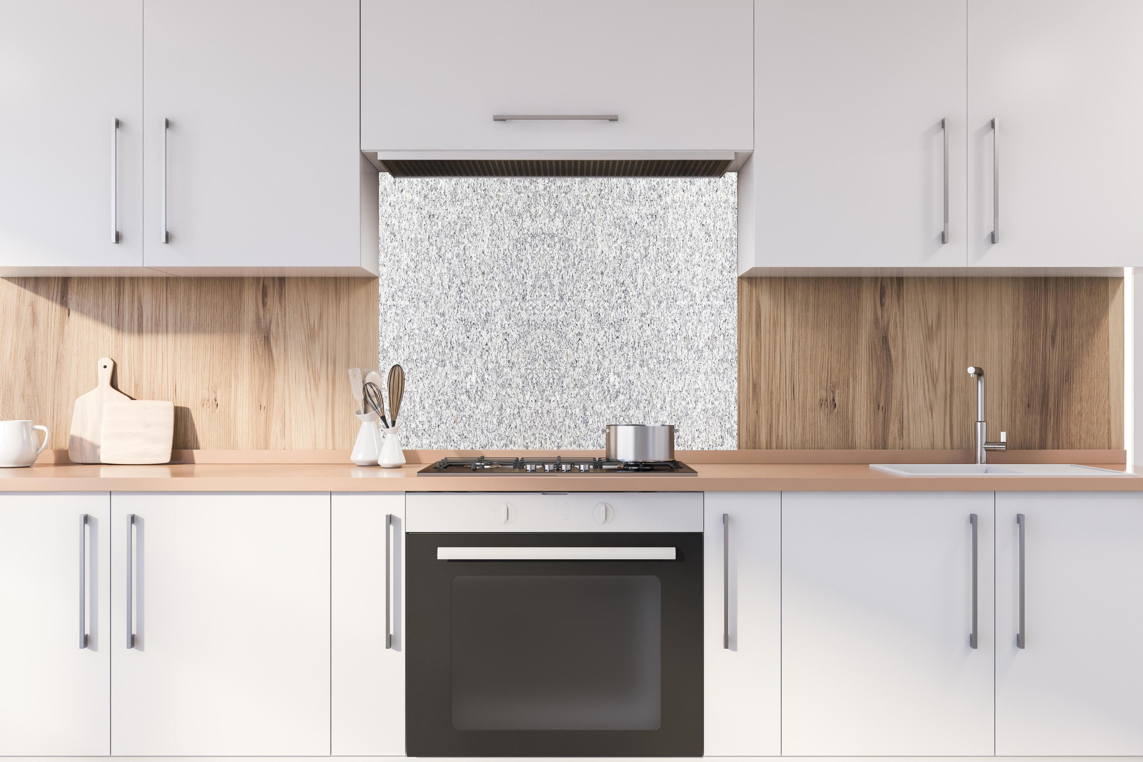 Spritzschutz - Hochwertige Weiß-Graue Terrazzo Bodenstruktur hinter einem Cerankochfeld zwischen Holz-Kochutensilien