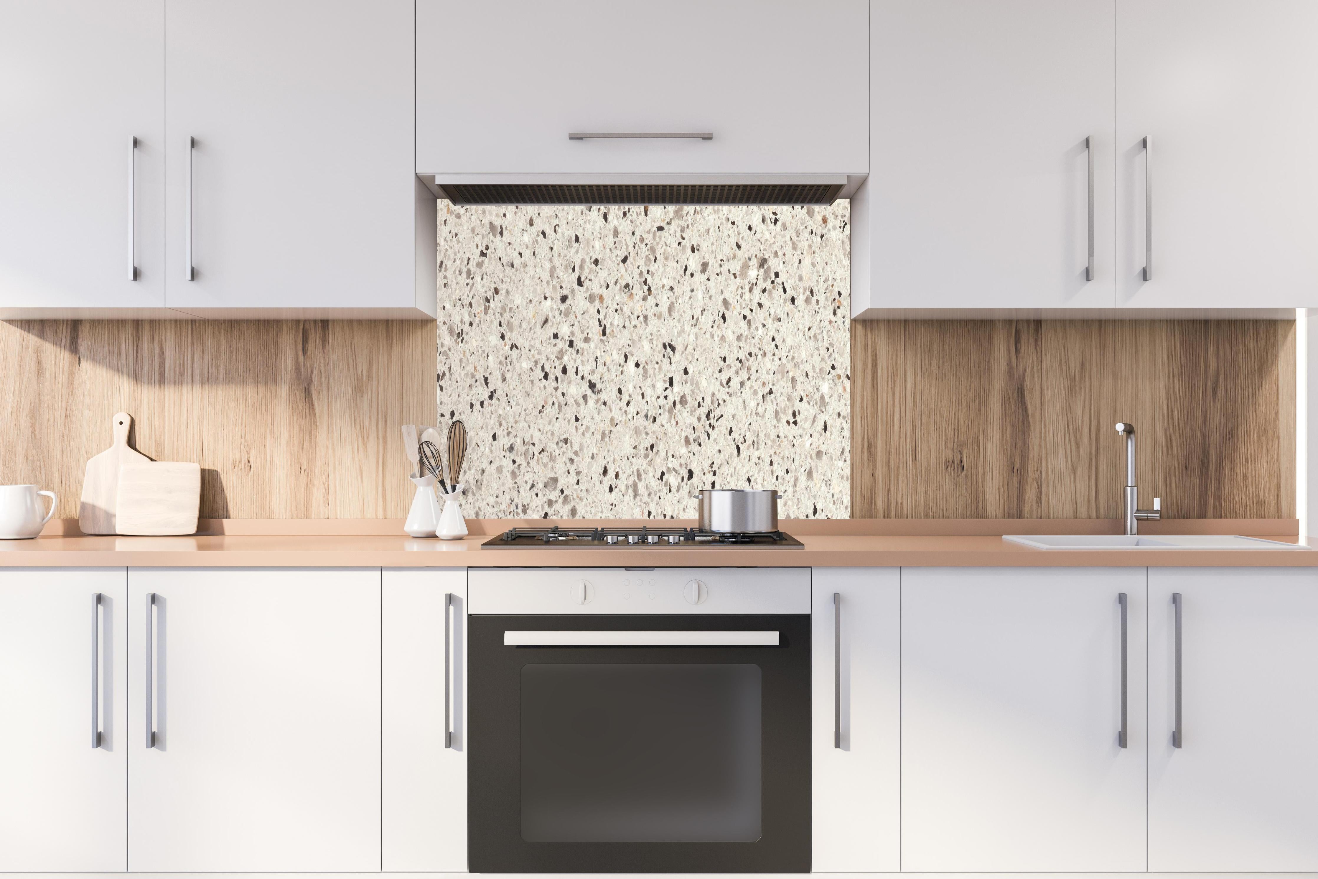 Spritzschutz - Hochwertige Weiß-und-Grau Terrazzo Textur hinter einem Cerankochfeld zwischen Holz-Kochutensilien