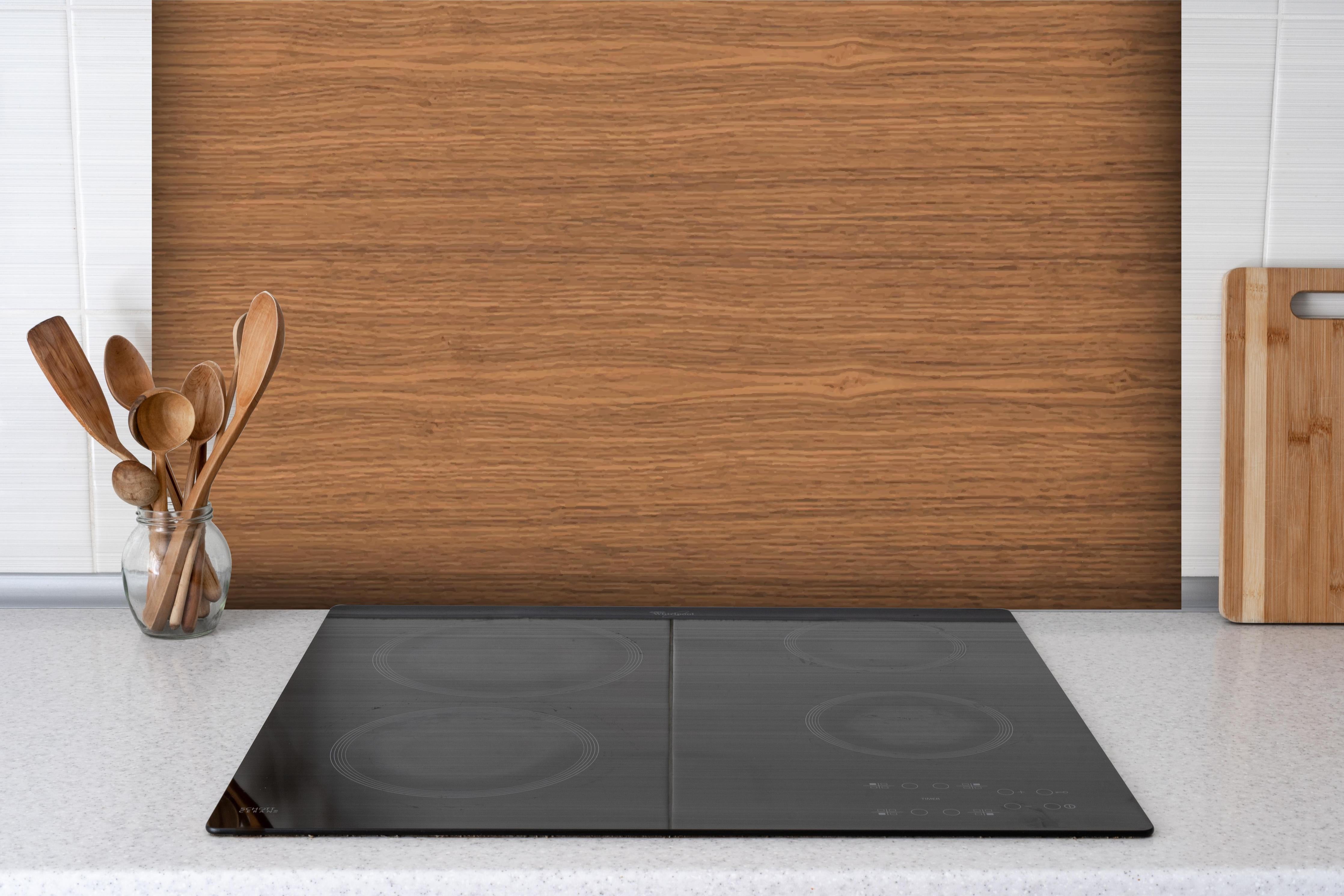 Spritzschutz - Hochwertige braune Echtholz-Struktur hinter einem Cerankochfeld zwischen Holz-Kochutensilien