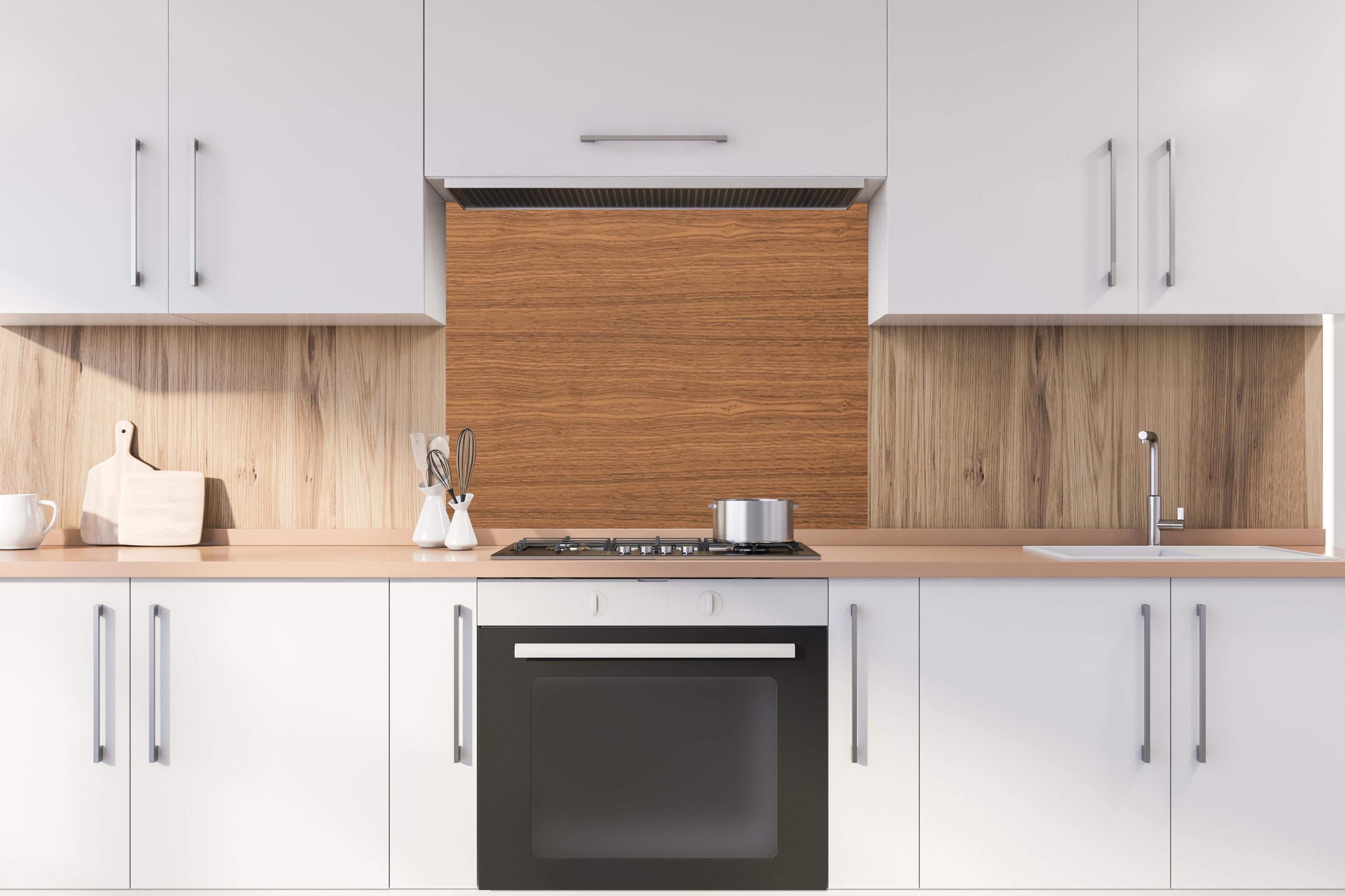 Spritzschutz - Hochwertige braune Echtholz-Struktur hinter einem Cerankochfeld zwischen Holz-Kochutensilien