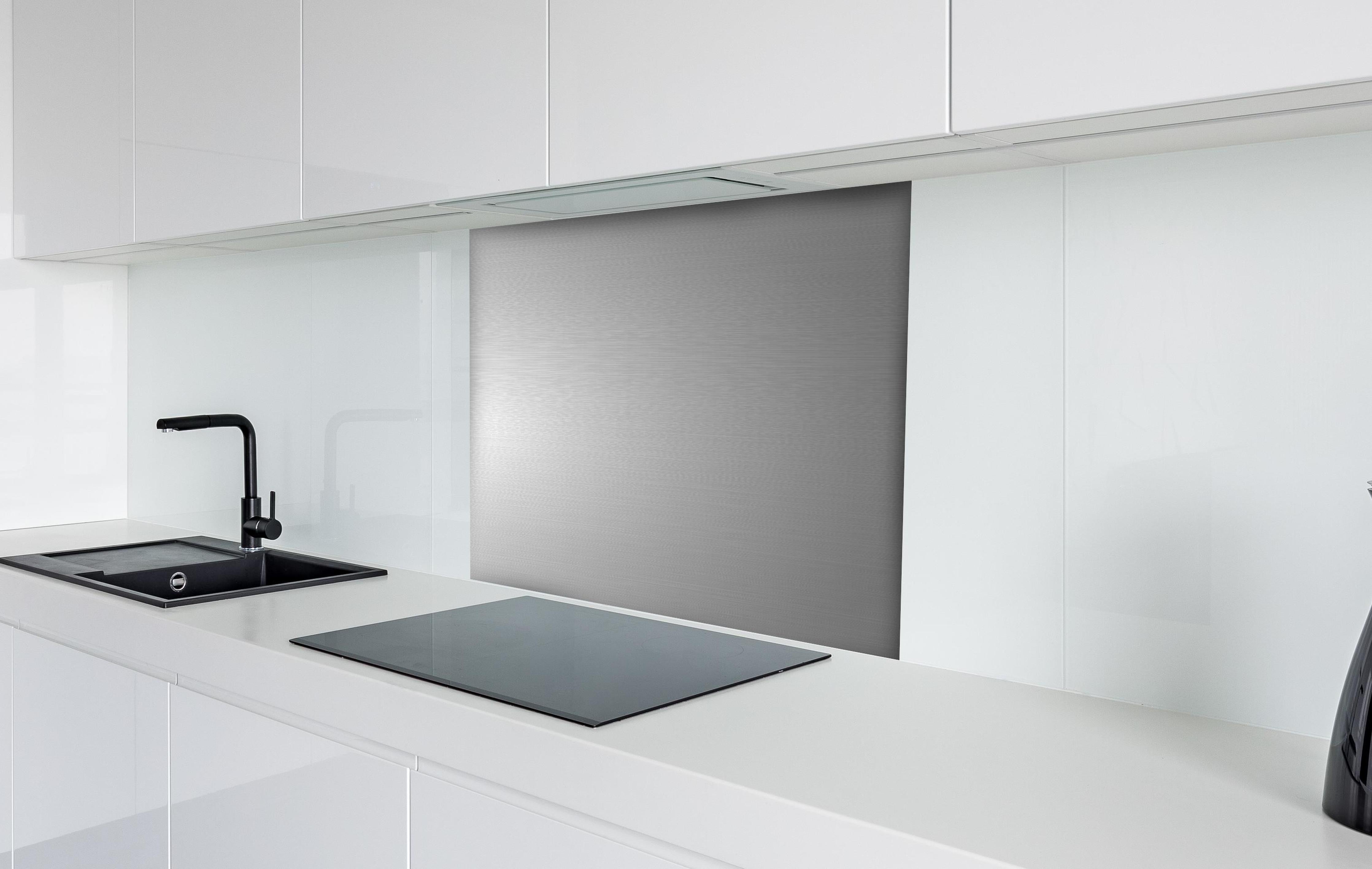 Spritzschutz - Hochwertige gebürstete Silber-Metallstruktur hinter einem Cerankochfeld zwischen Holz-Kochutensilien