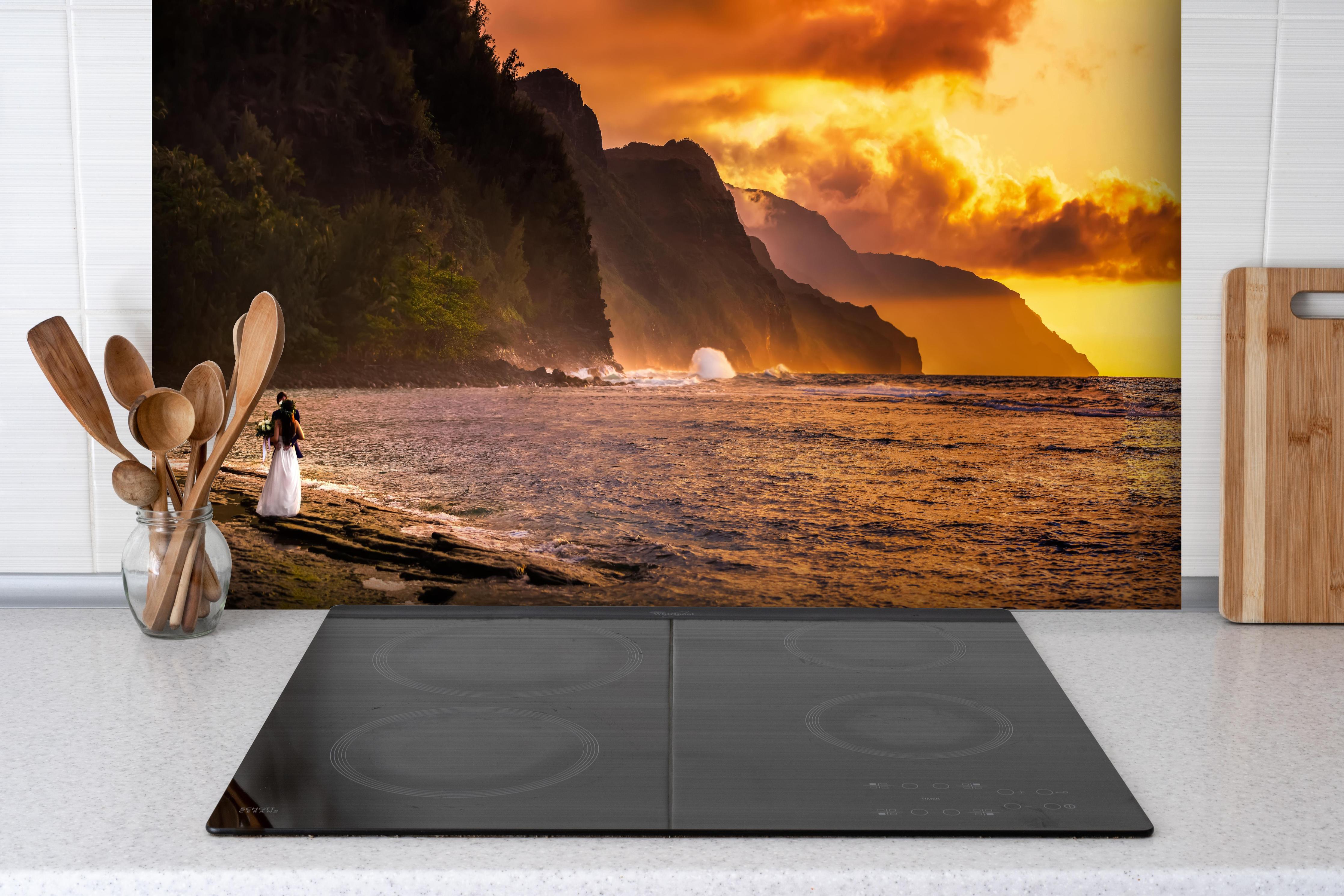 Spritzschutz - Hochzeitspaar auf Hawaii hinter einem Cerankochfeld zwischen Holz-Kochutensilien