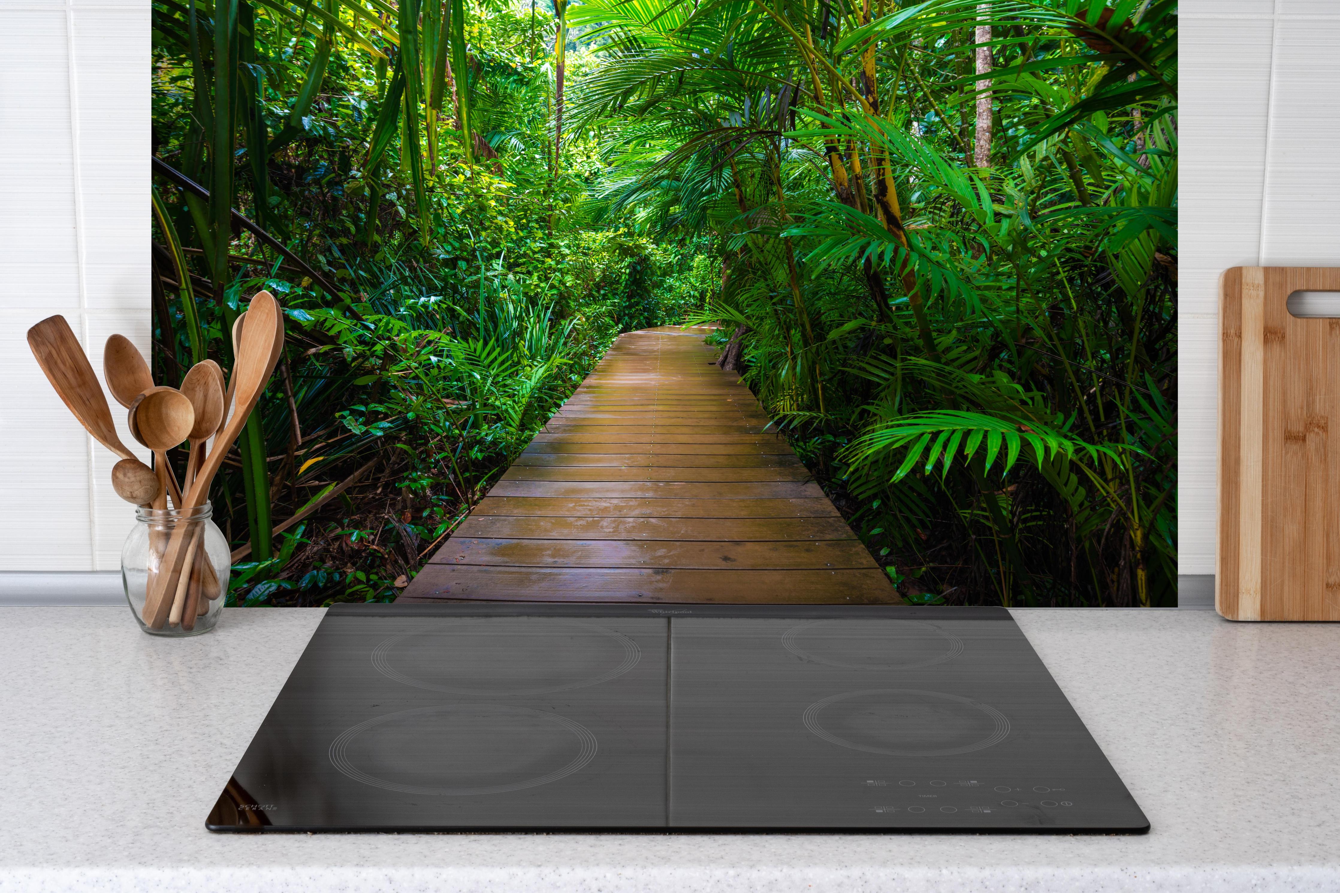 Spritzschutz - Holzweg durch dichten grünen Mangrovenwald hinter einem Cerankochfeld zwischen Holz-Kochutensilien