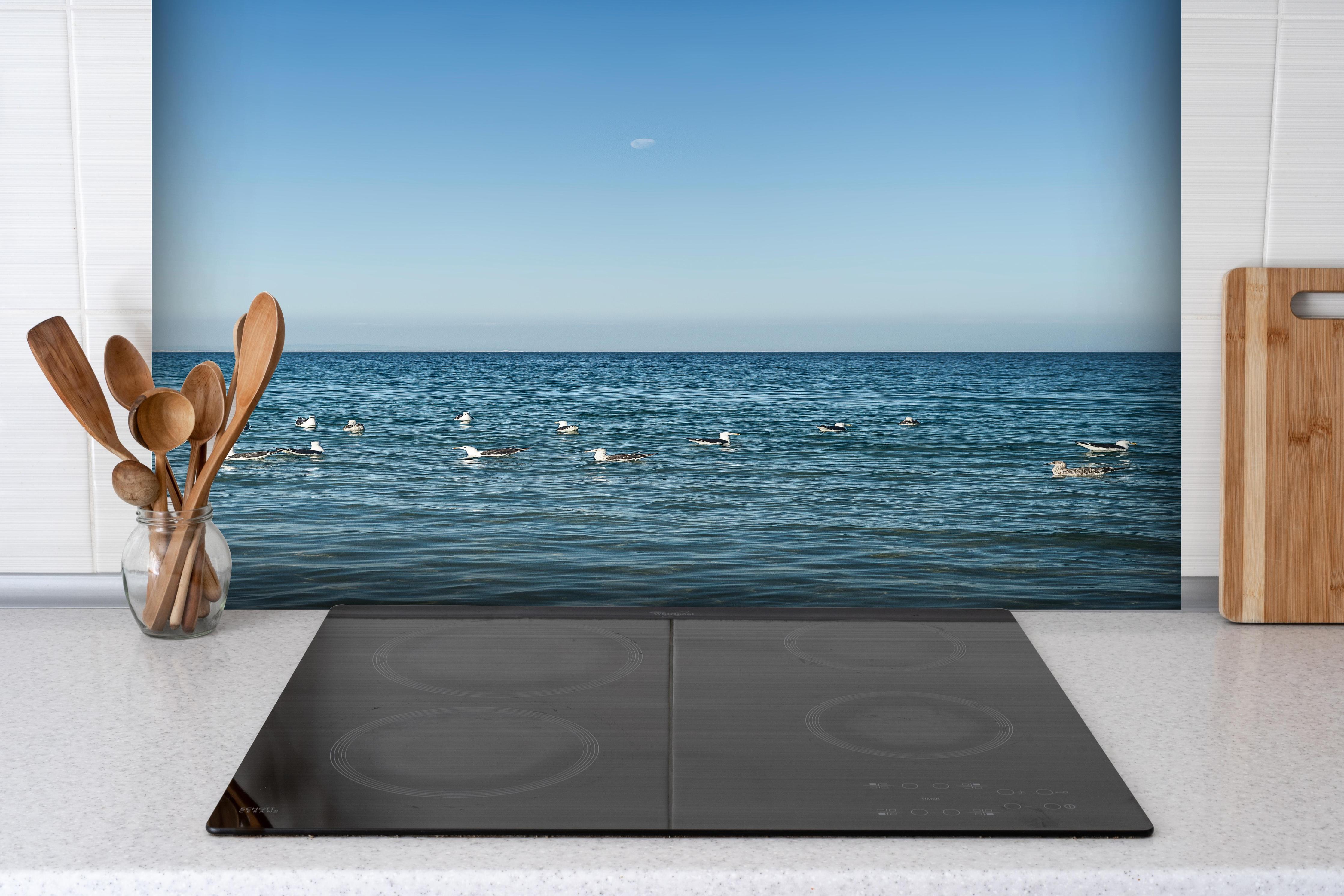 Spritzschutz - Idyllic Seashore with Flock of Birds hinter einem Cerankochfeld zwischen Holz-Kochutensilien
