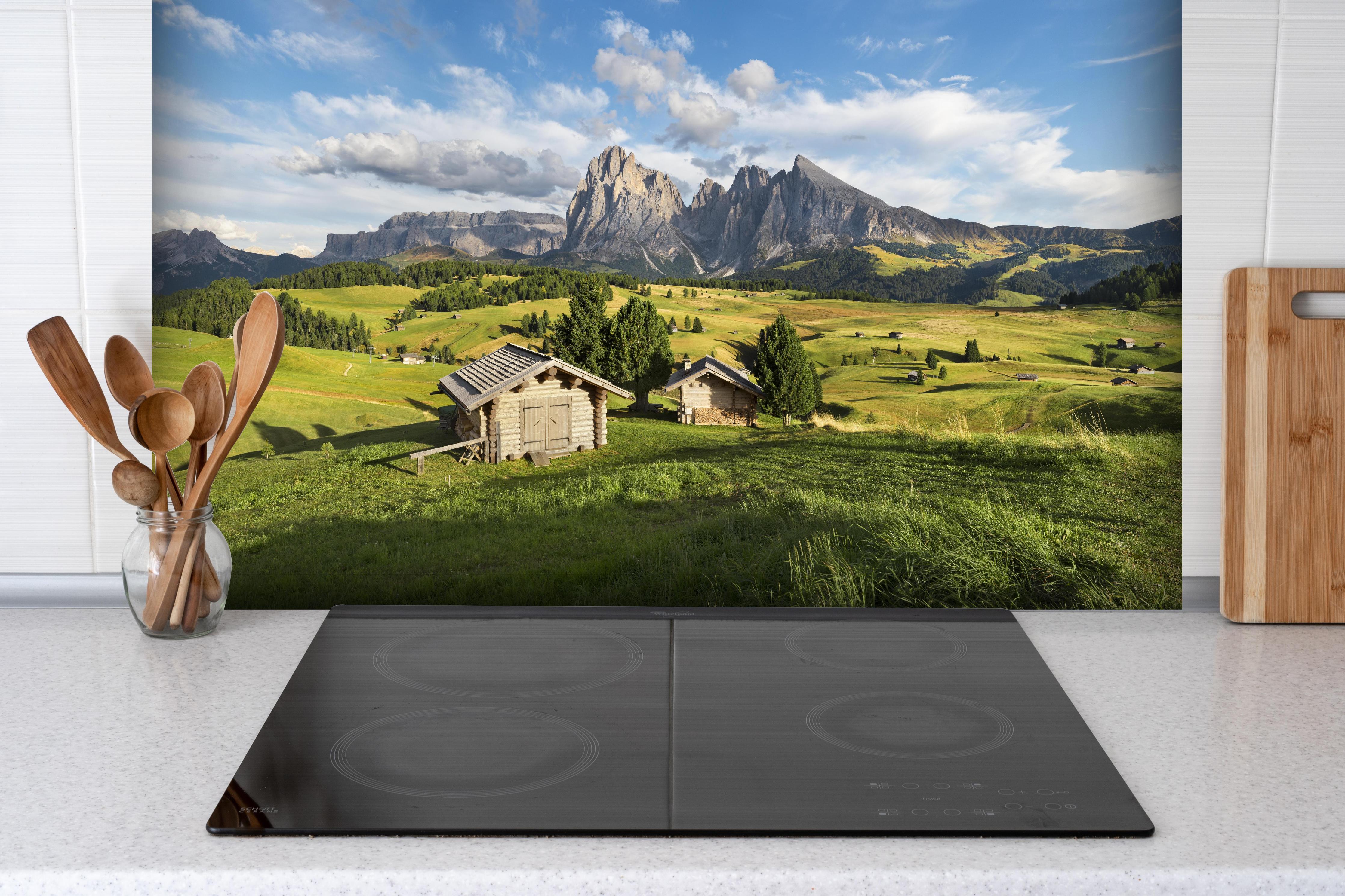 Spritzschutz - Idyllische Alpenlandschaft in Sommerfrische hinter einem Cerankochfeld zwischen Holz-Kochutensilien
