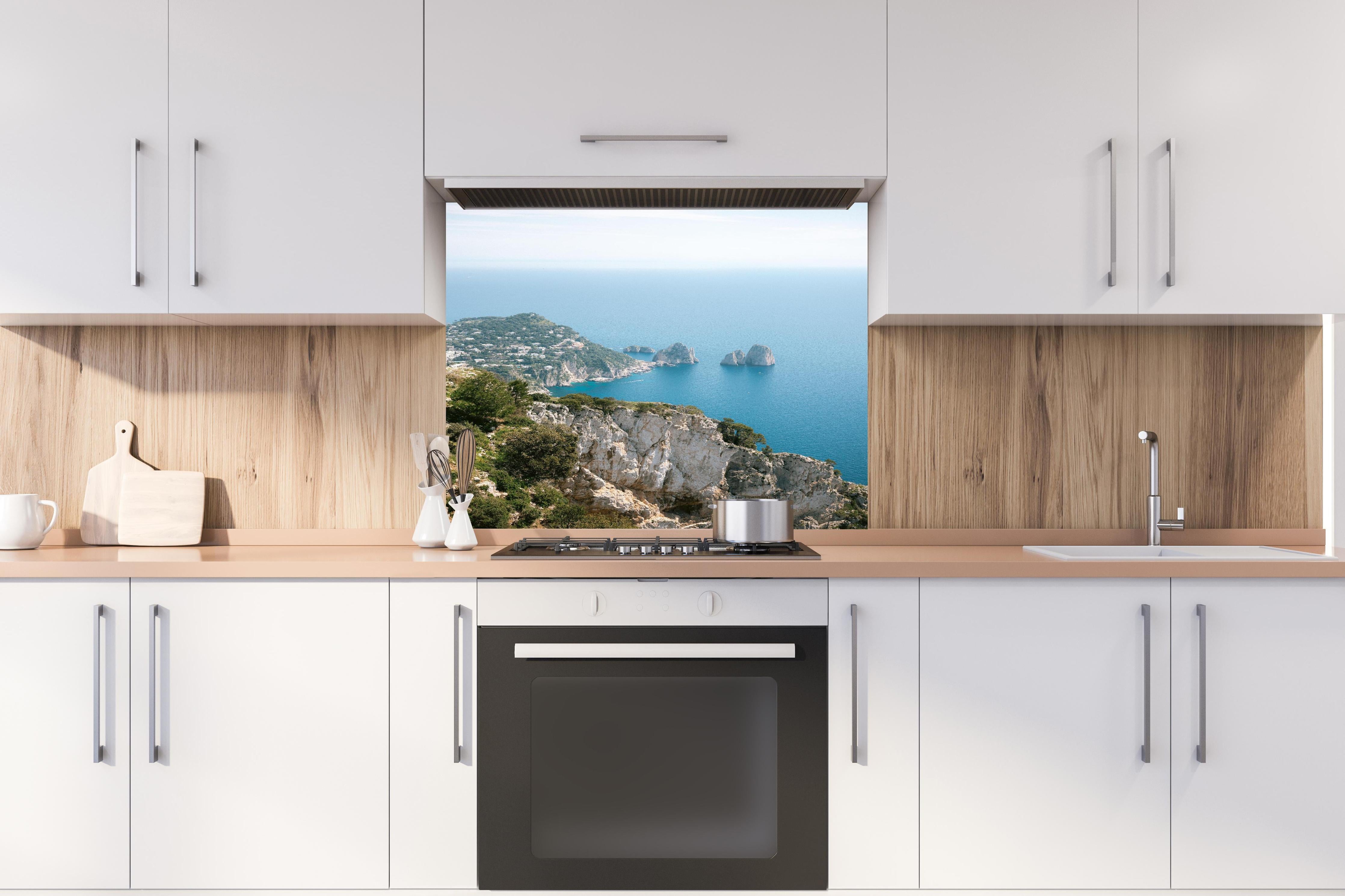 Spritzschutz - Idyllische Capri Küste und blaues Meer hinter einem Cerankochfeld zwischen Holz-Kochutensilien