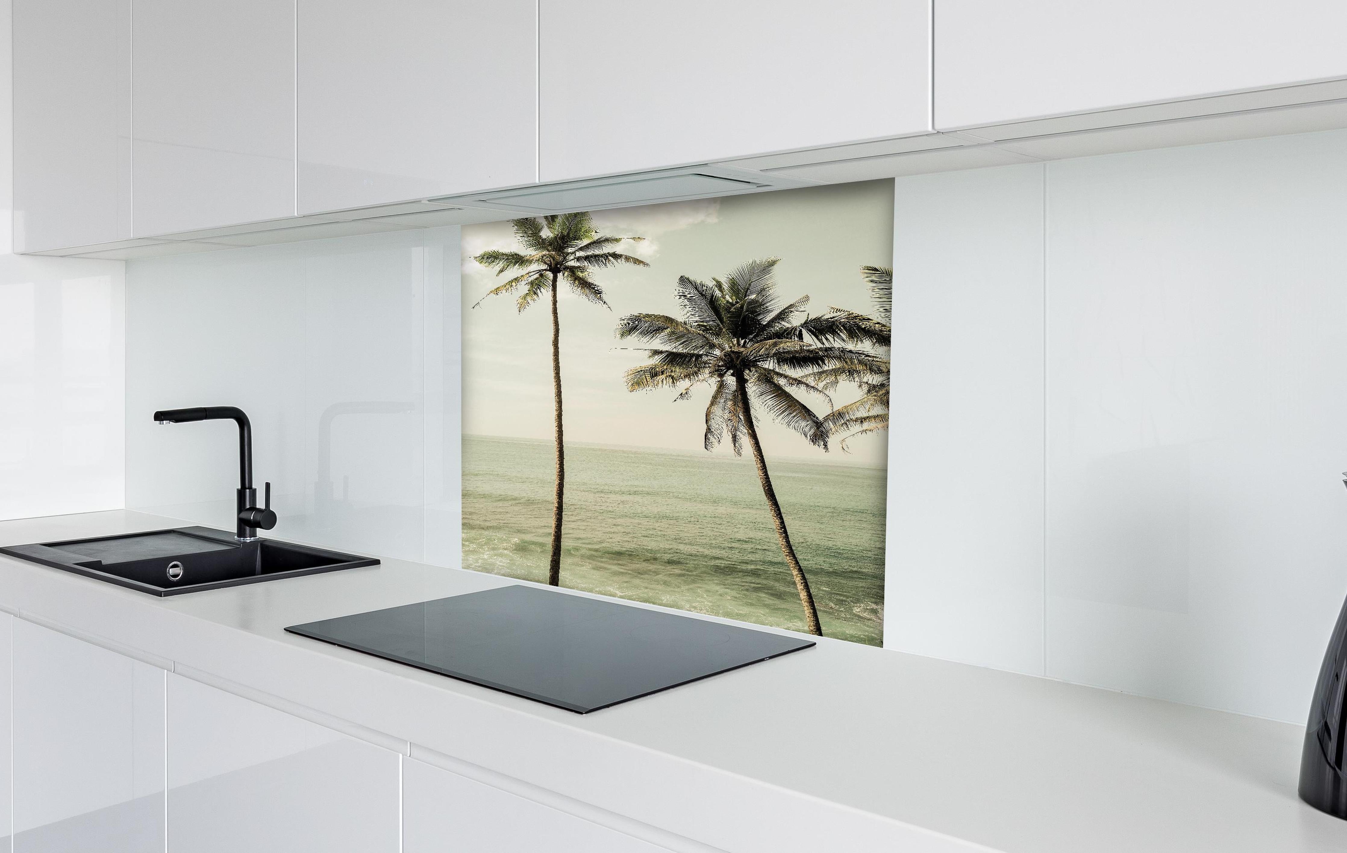 Spritzschutz - Idyllische Strandpalmen über ruhigem Meer hinter einem Cerankochfeld zwischen Holz-Kochutensilien