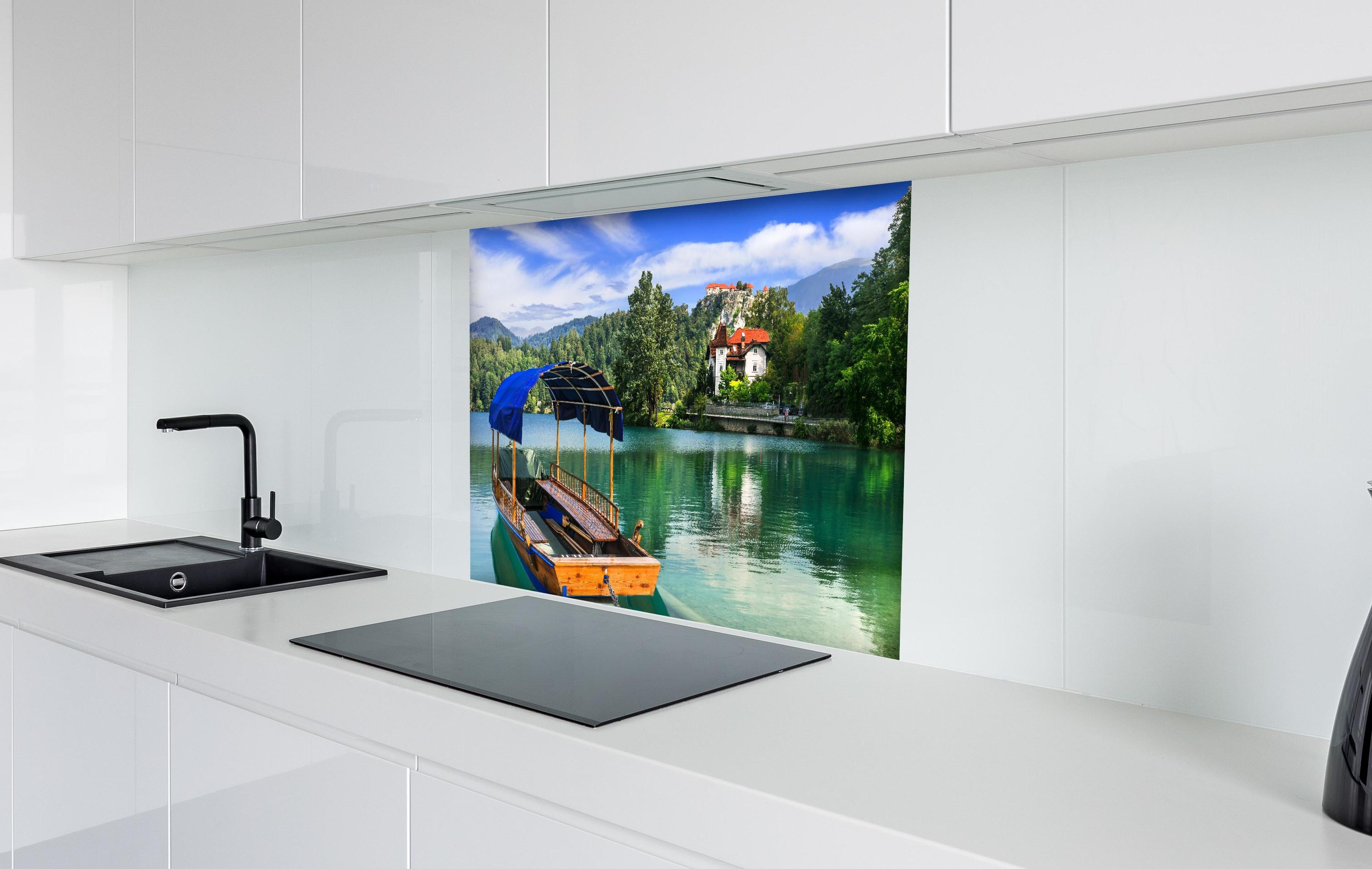 Spritzschutz - Idyllischer Bled See, Holzboot, Slowenien hinter einem Cerankochfeld zwischen Holz-Kochutensilien