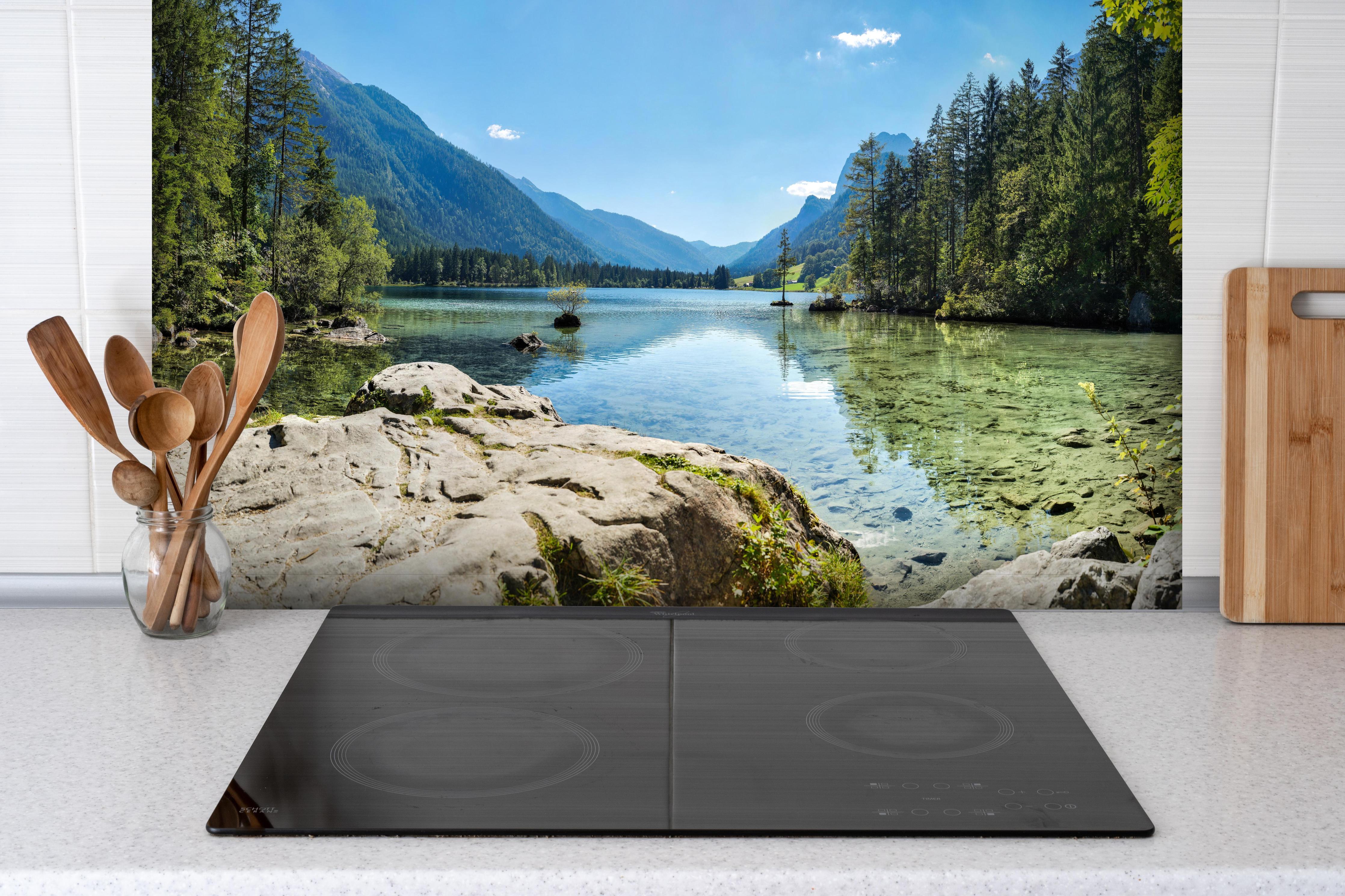 Spritzschutz - Idyllischer Königssee hinter einem Cerankochfeld zwischen Holz-Kochutensilien