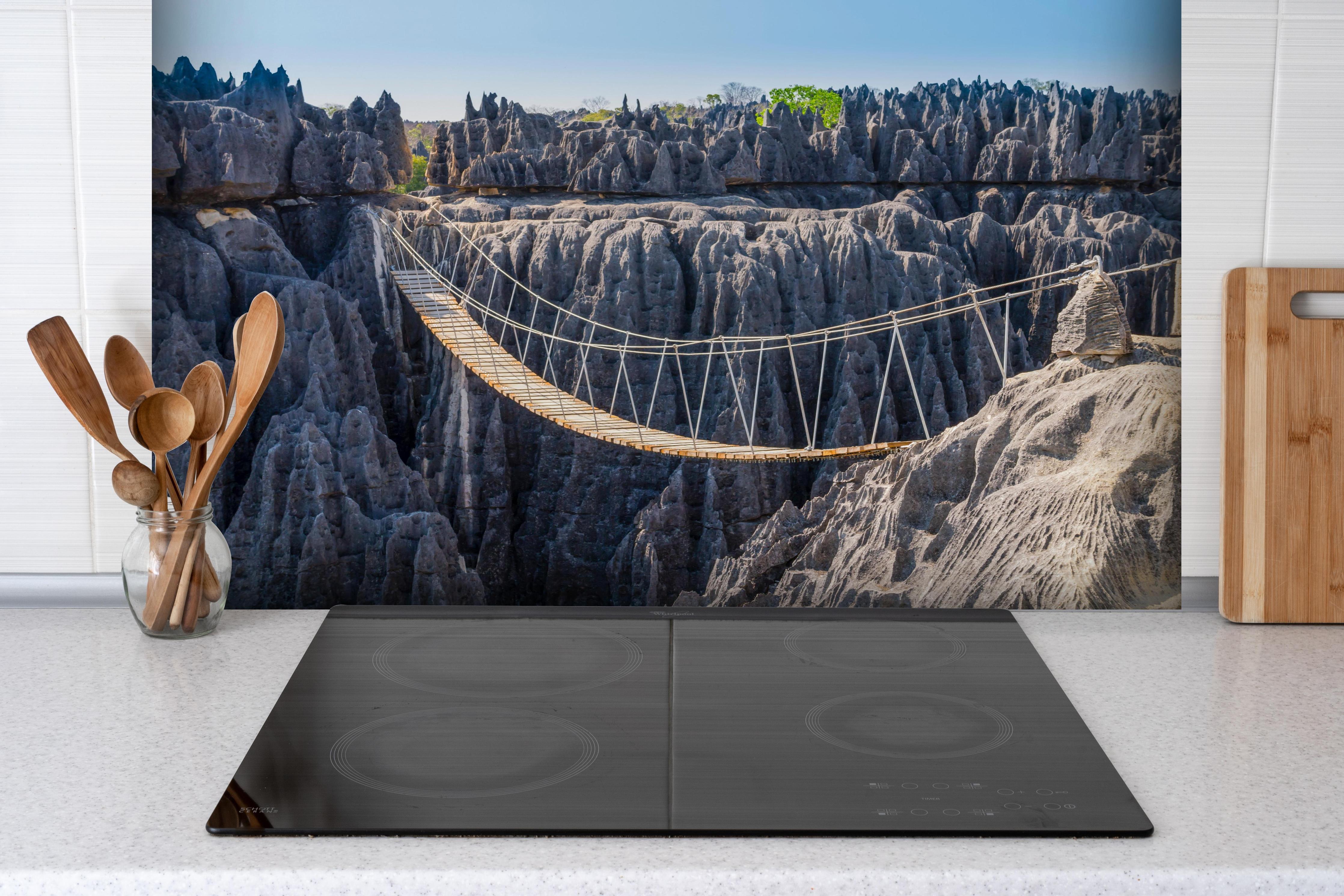 Spritzschutz - Impressionante Hängebrücke Tsingy hinter einem Cerankochfeld zwischen Holz-Kochutensilien