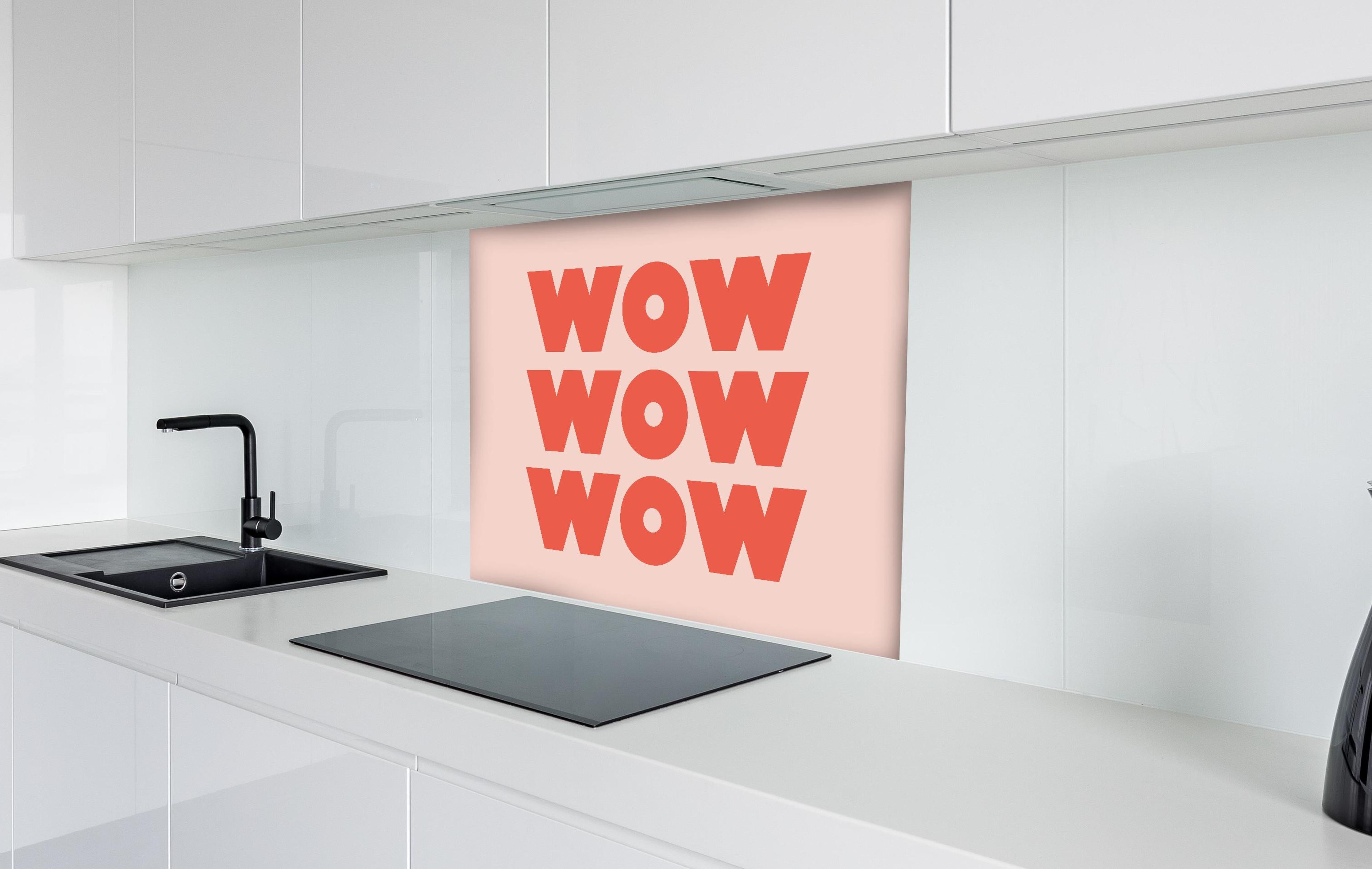 Spritzschutz - Inspirierender 'WOW' Text auf Pinkem Hintergrund hinter einem Cerankochfeld zwischen Holz-Kochutensilien