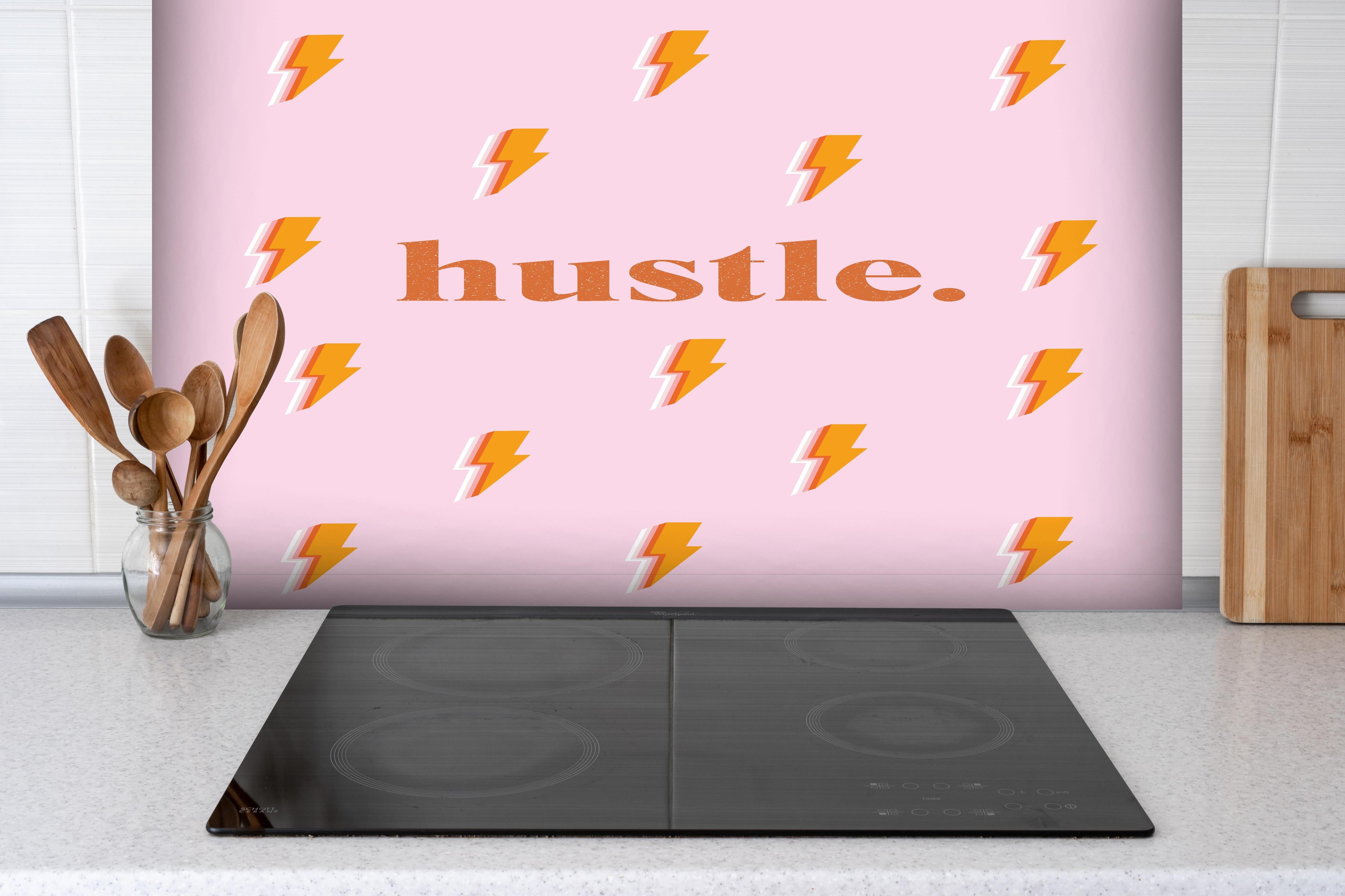 Spritzschutz - Inspirierendes Blitz-Motiv in Pink und Orange hinter einem Cerankochfeld zwischen Holz-Kochutensilien