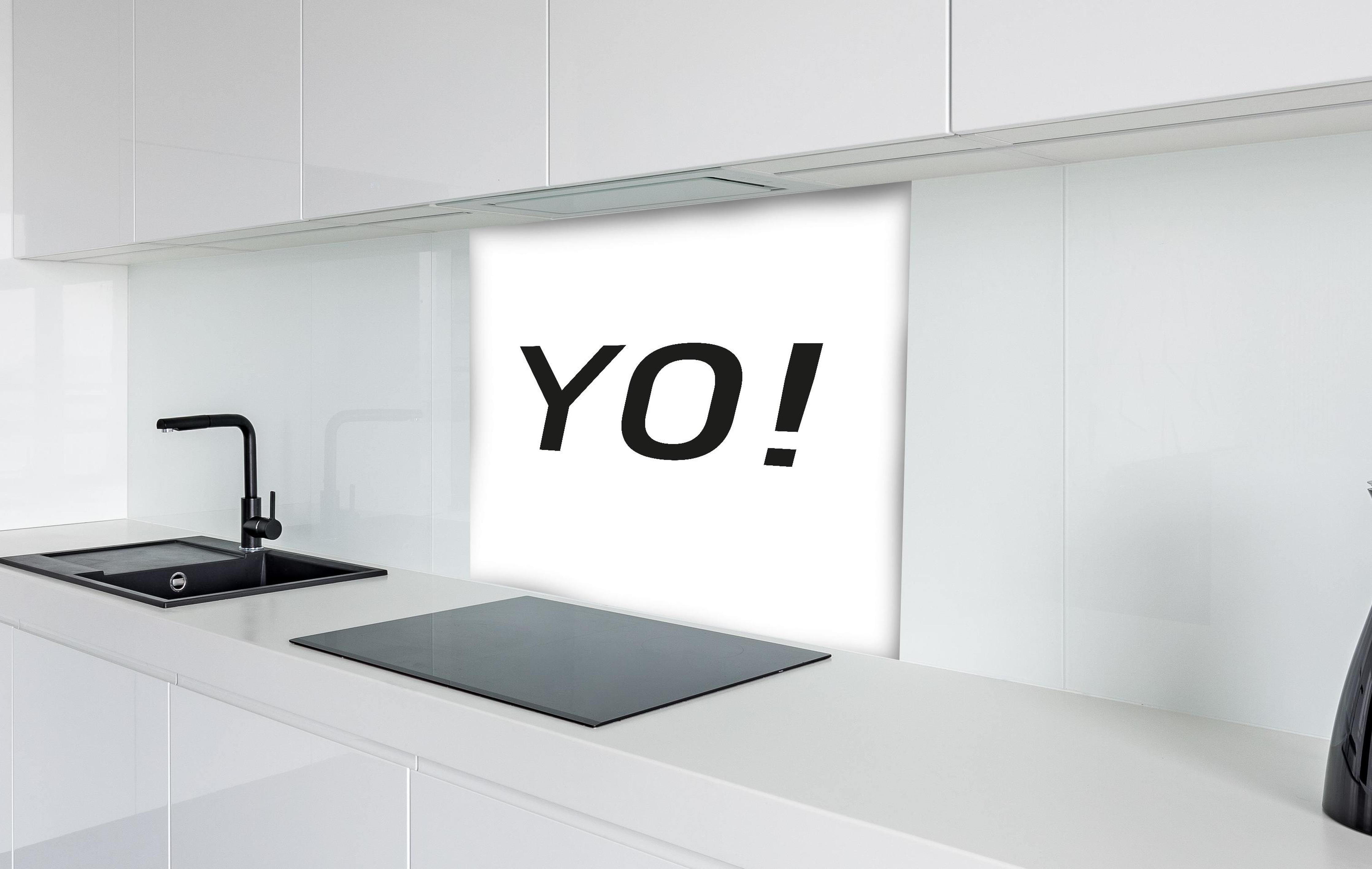 Spritzschutz - Inspirierendes 'YO!' in Schwarz auf Weiß hinter einem Cerankochfeld zwischen Holz-Kochutensilien