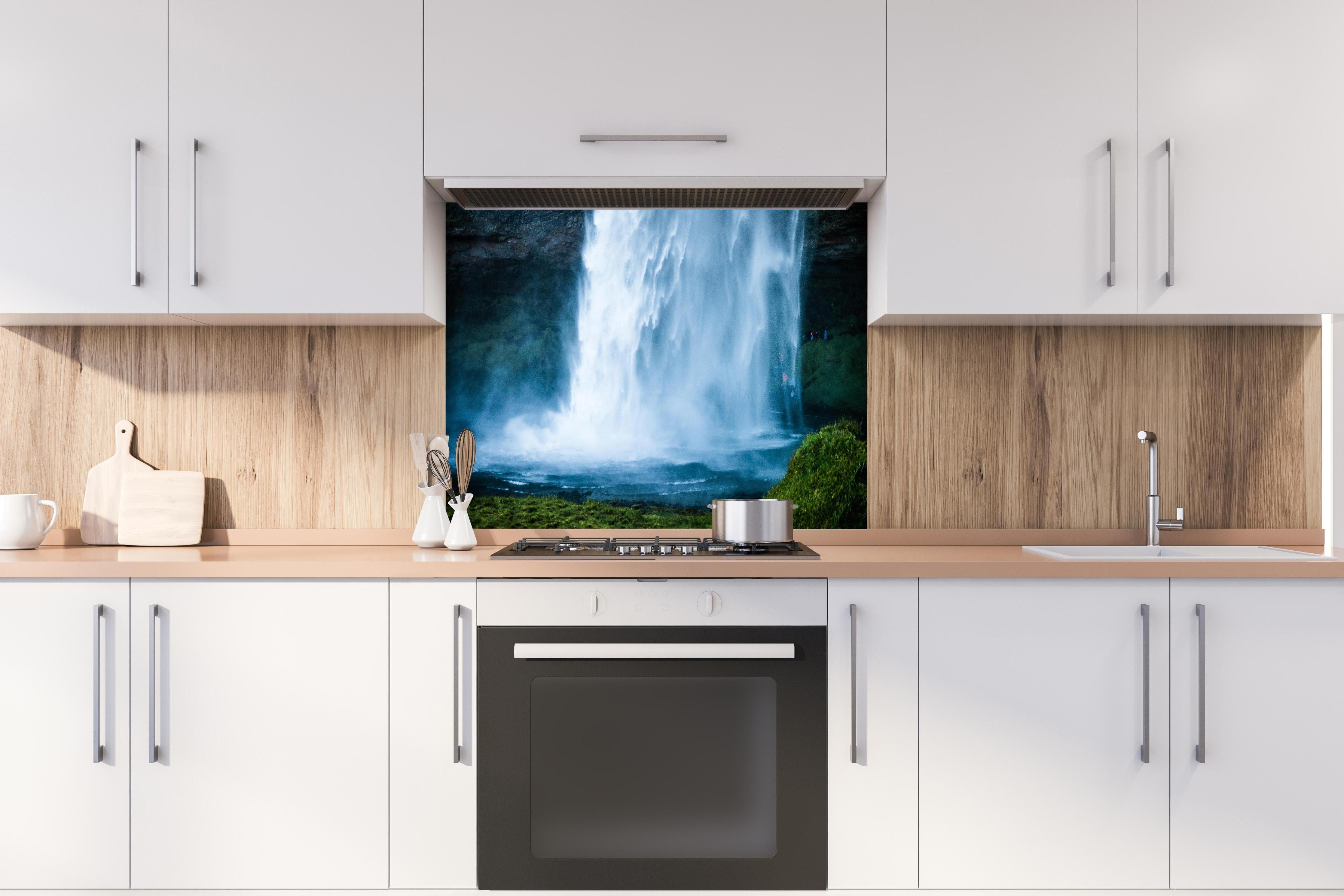 Spritzschutz - Islands beeindruckender Wasserfall in Blau hinter einem Cerankochfeld zwischen Holz-Kochutensilien
