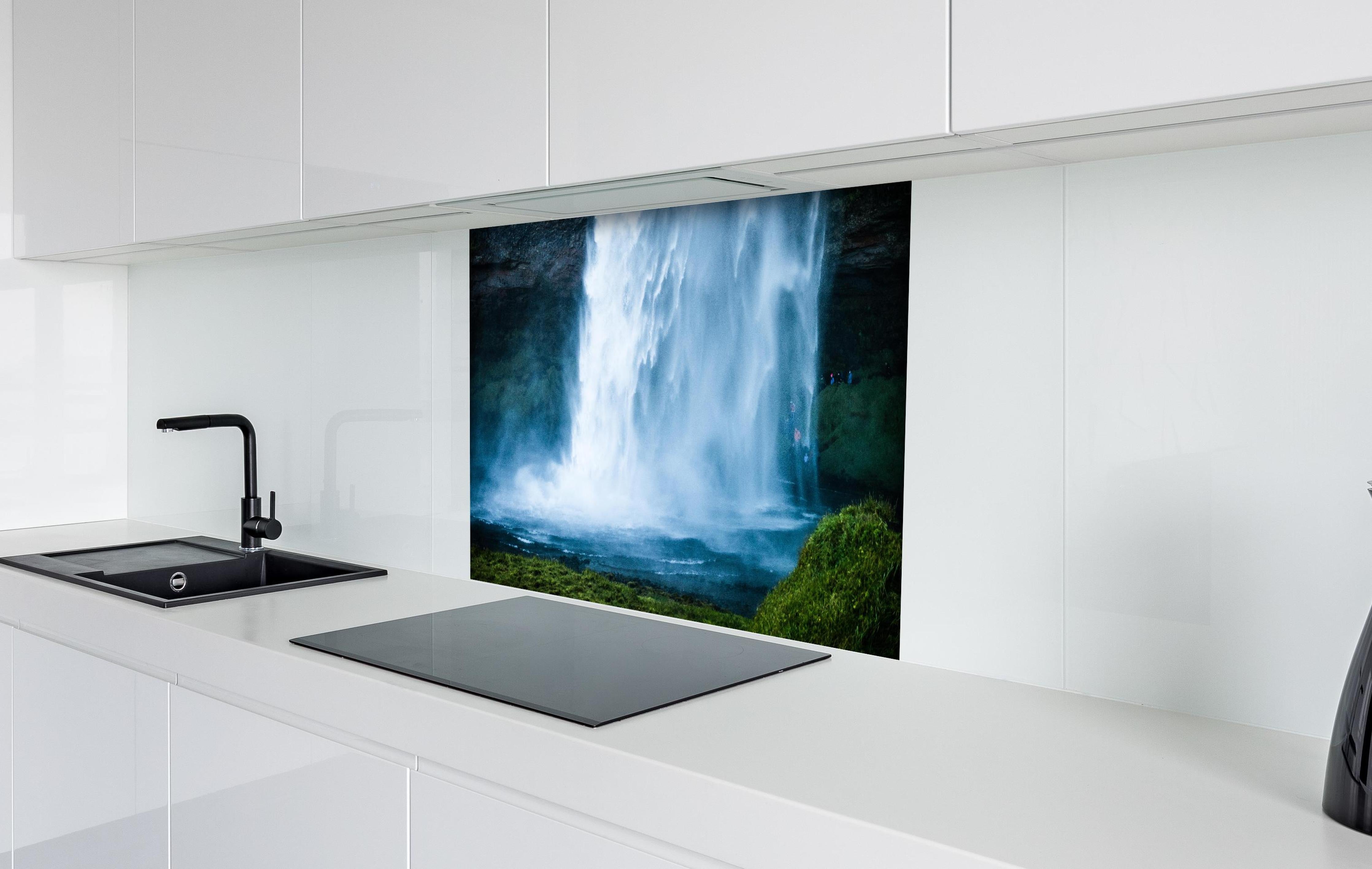 Spritzschutz - Islands beeindruckender Wasserfall in Blau hinter einem Cerankochfeld zwischen Holz-Kochutensilien