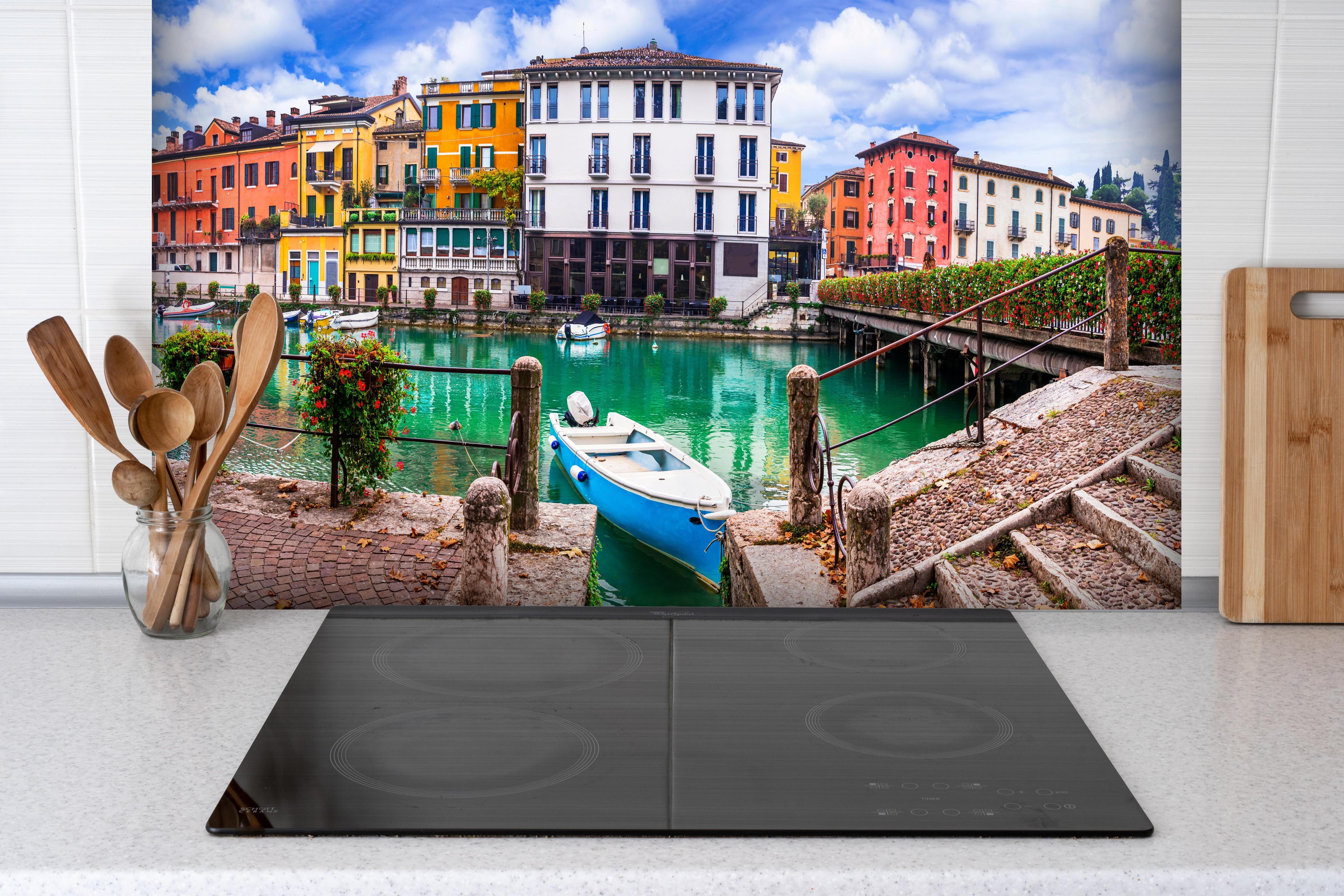 Spritzschutz - Italien - Peschiera del Garda hinter einem Cerankochfeld zwischen Holz-Kochutensilien