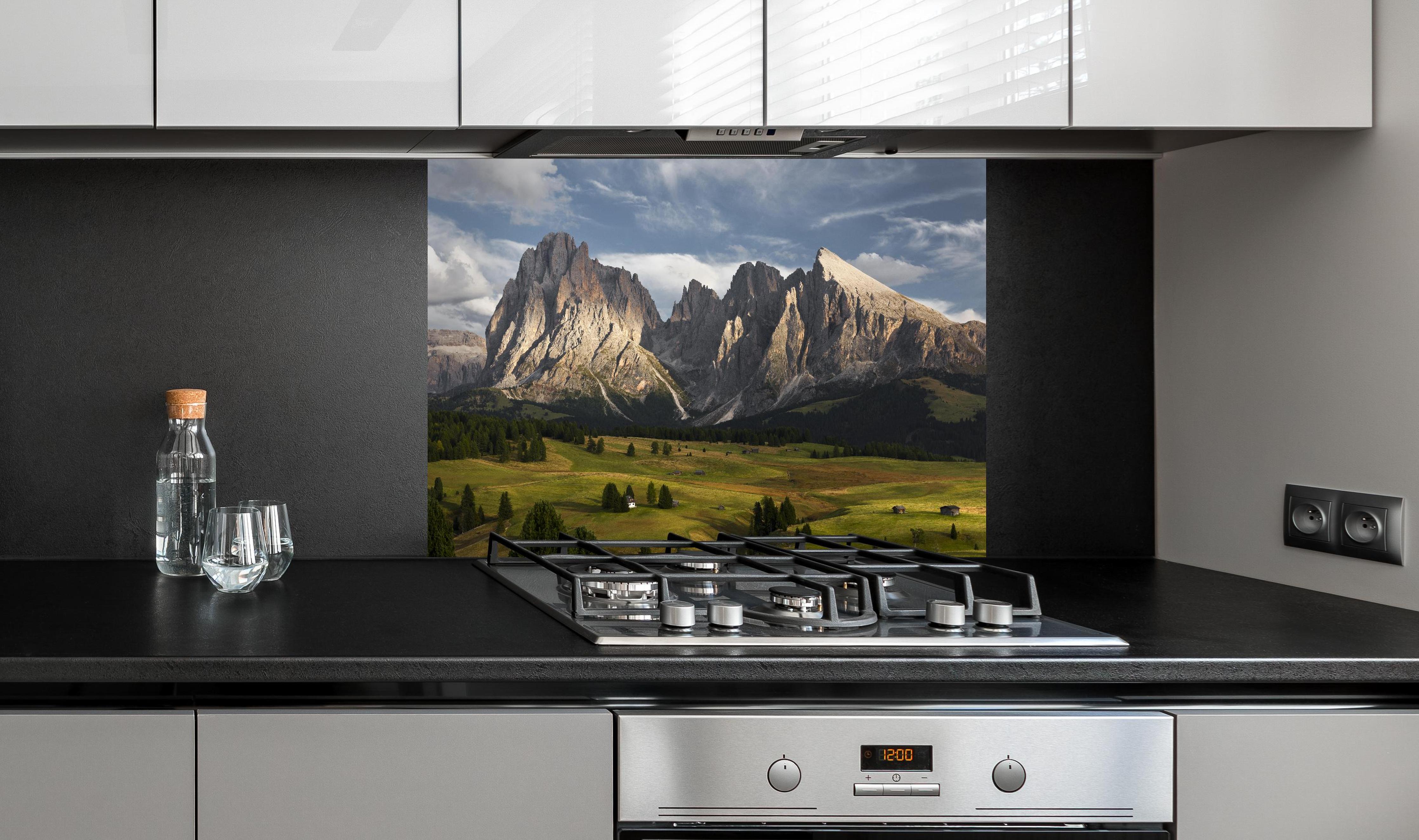 Spritzschutz - Italienische Alpen Dolomiten Berge Wiese hinter einem Cerankochfeld zwischen Holz-Kochutensilien