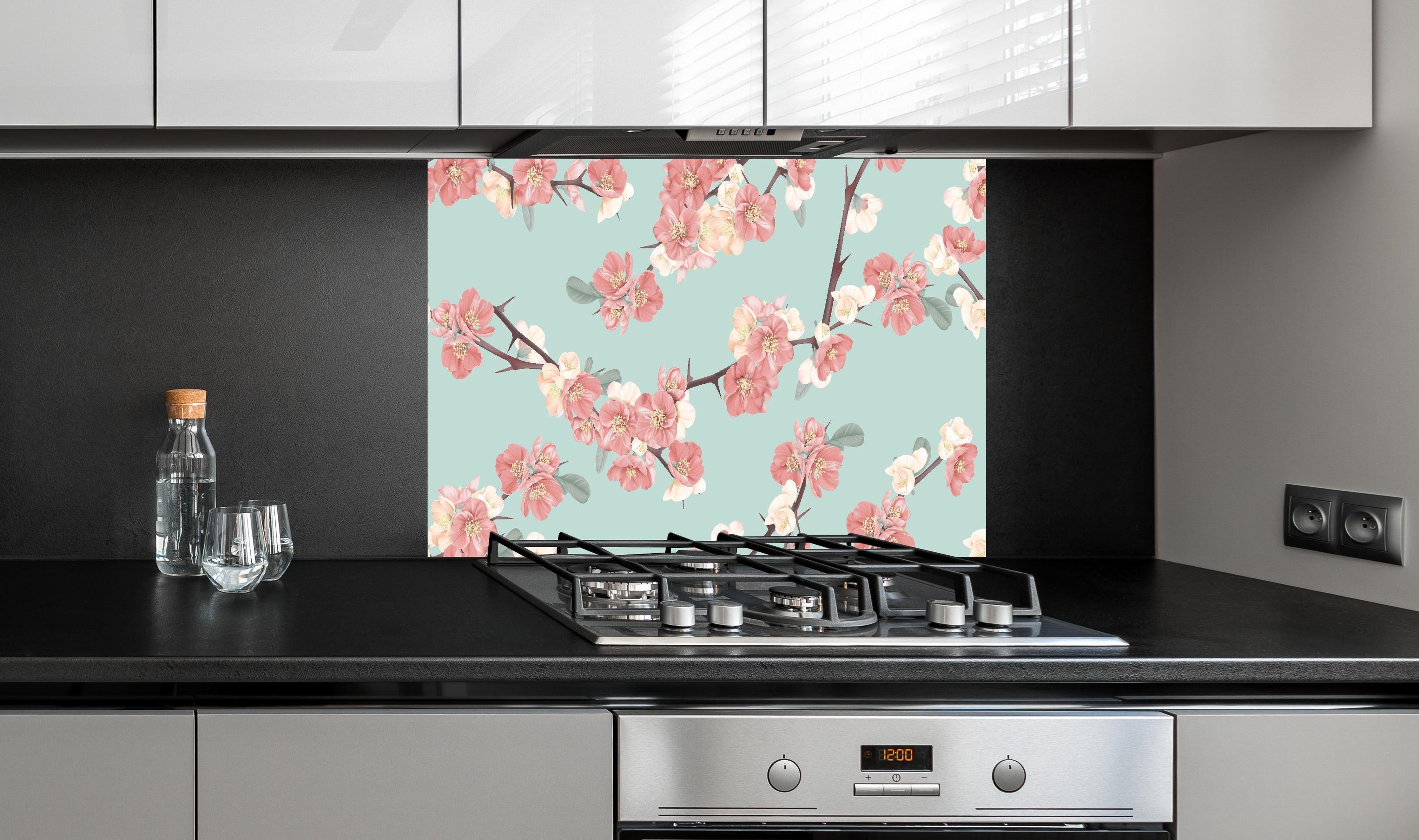 Spritzschutz - Japanische Quitten Blumen Muster Pastellblau hinter einem Cerankochfeld zwischen Holz-Kochutensilien