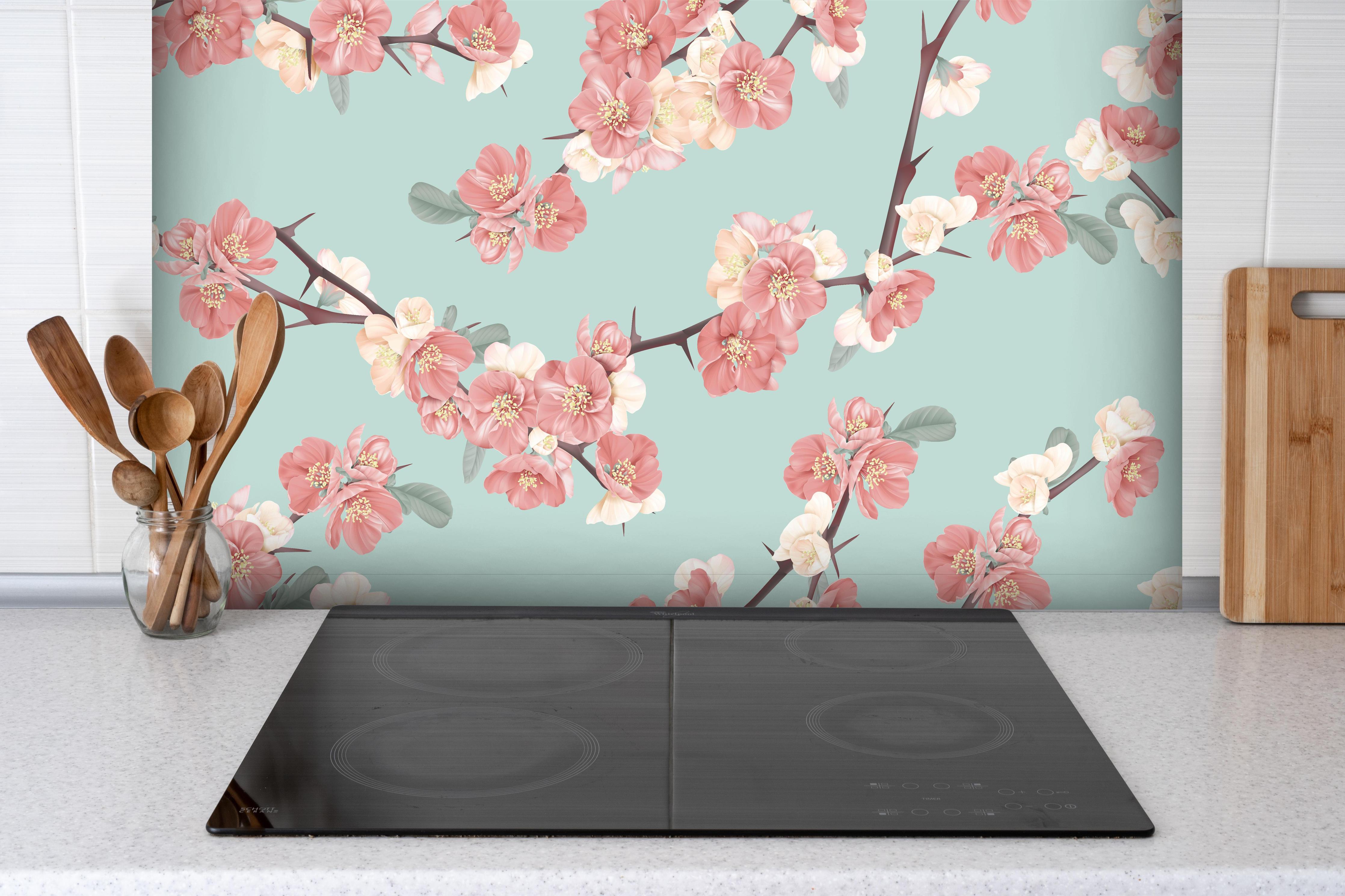 Spritzschutz - Japanische Quittenblüte auf Pastellblau hinter einem Cerankochfeld zwischen Holz-Kochutensilien