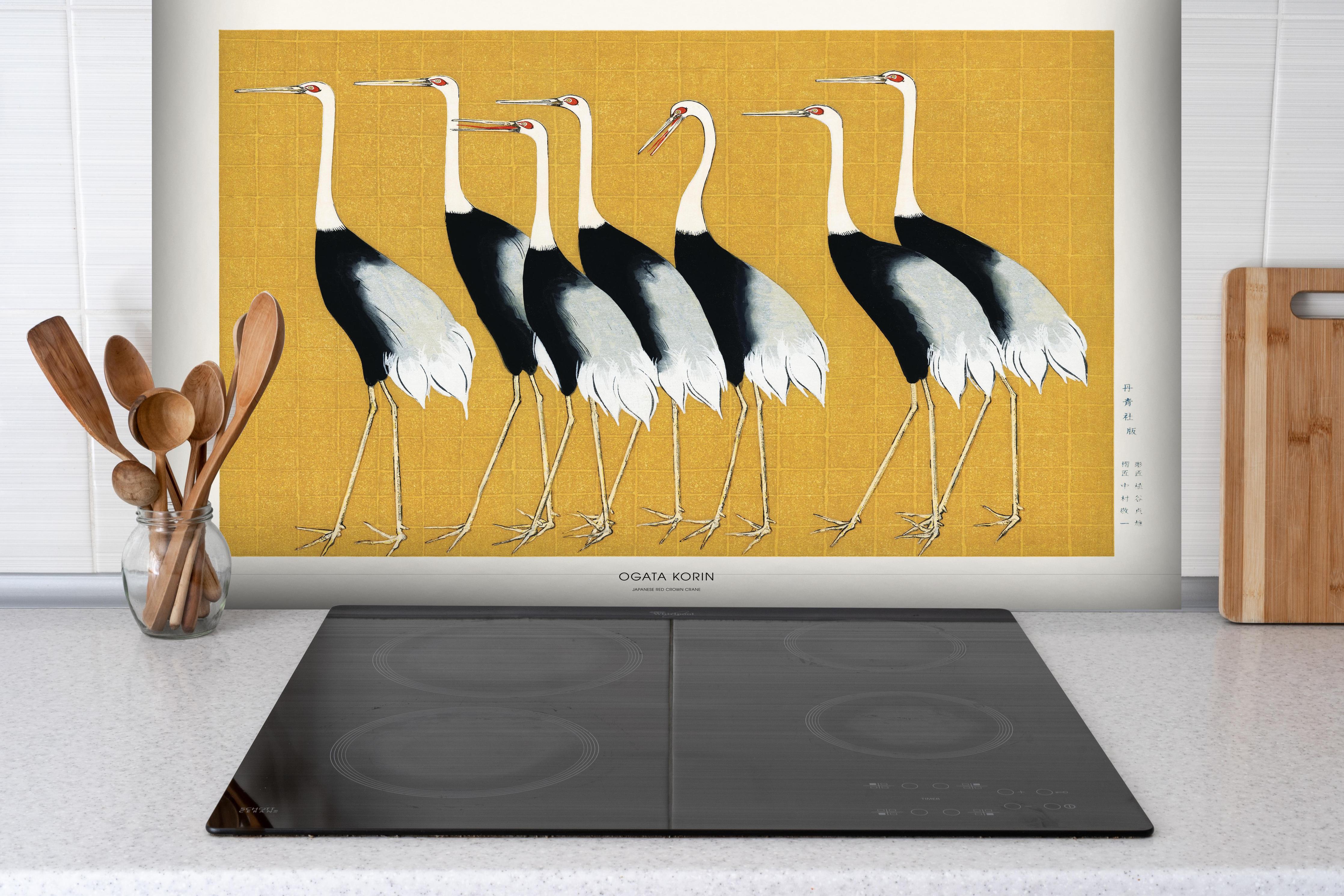 Spritzschutz - Japanischer Mandschurenkranich - Gold hinter einem Cerankochfeld zwischen Holz-Kochutensilien